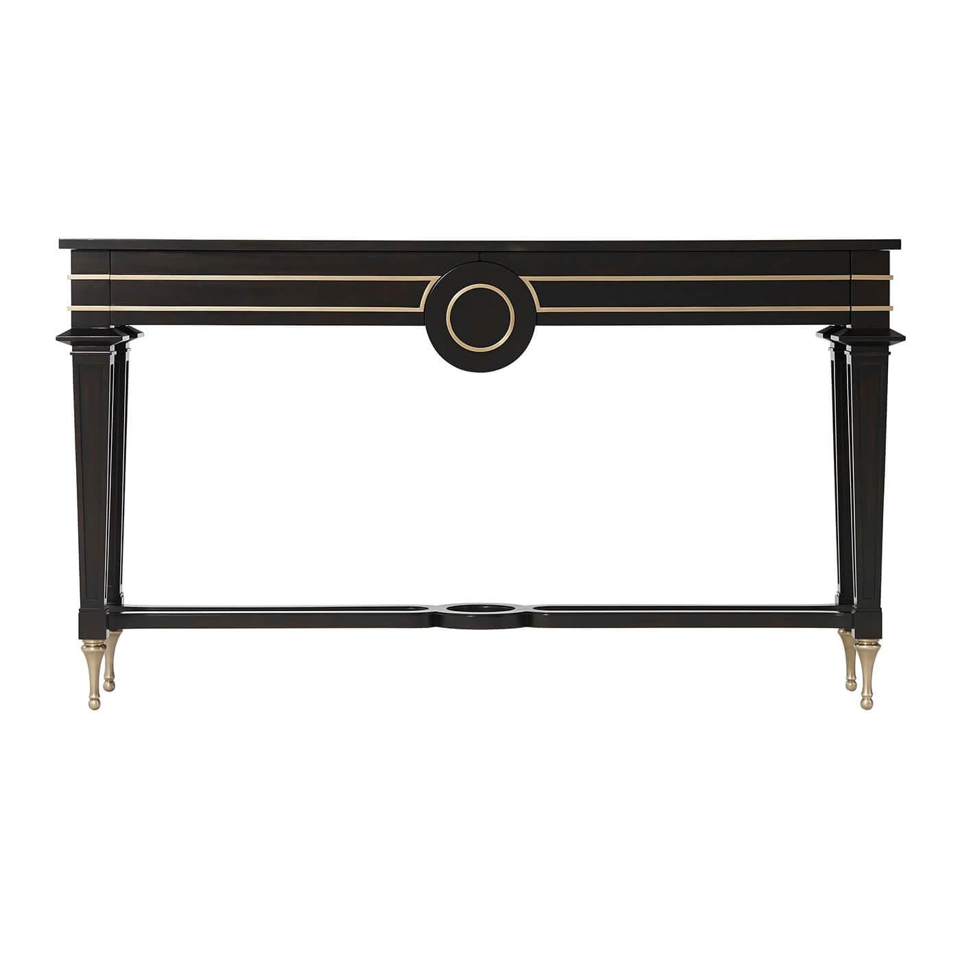 A midcentury style console table, the rectangular top above two frieze drawers centered by a roundel and decorated with brass molding, on tapering square legs joined by a shaped X-stretcher, with brass peg feet.
Dimensions: 60.5