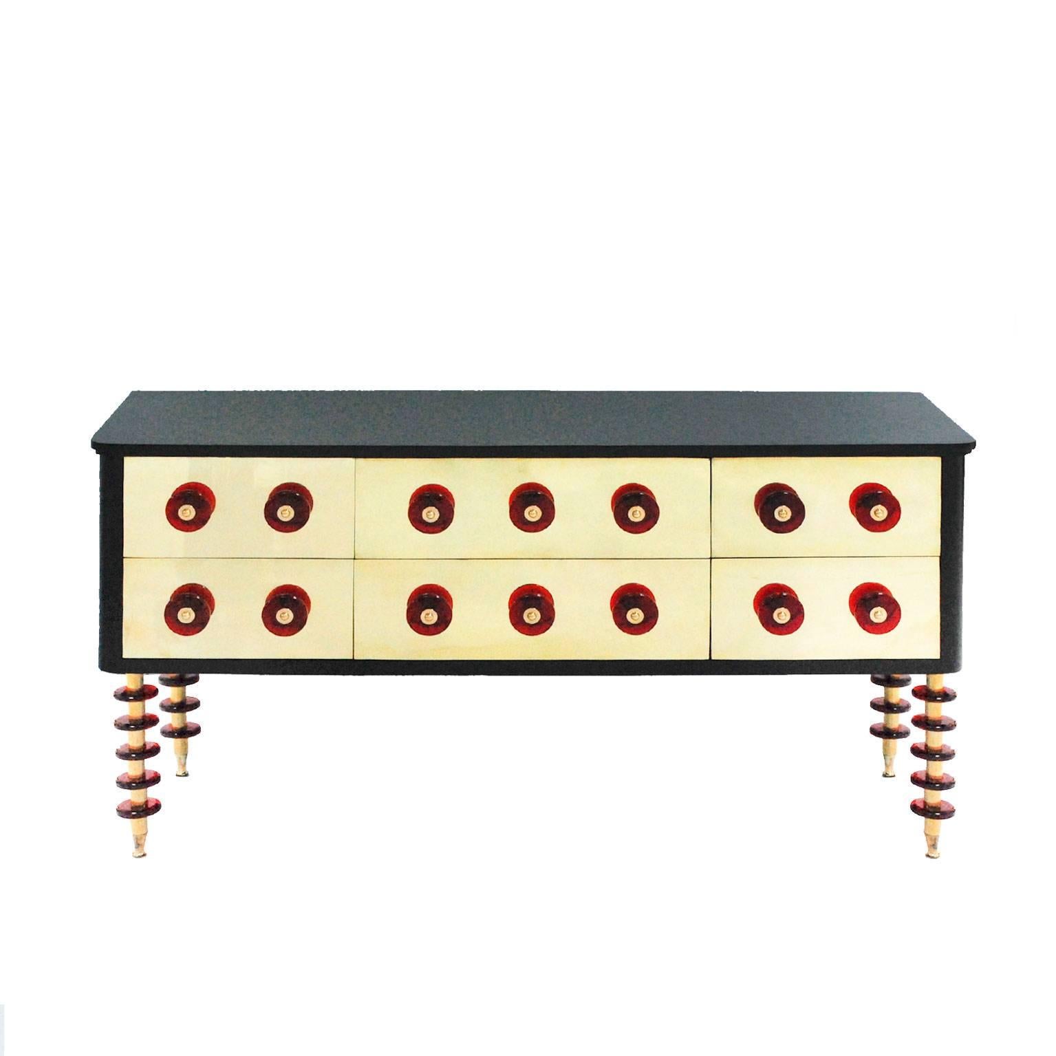 Credenza italiana contemporanea composta da sei cassetti. Struttura in legno massiccio laccato in nero con dettagli in vetro di Murano rosso e ottone.

Il nostro obiettivo principale è la soddisfazione del cliente, quindi includiamo nel prezzo di