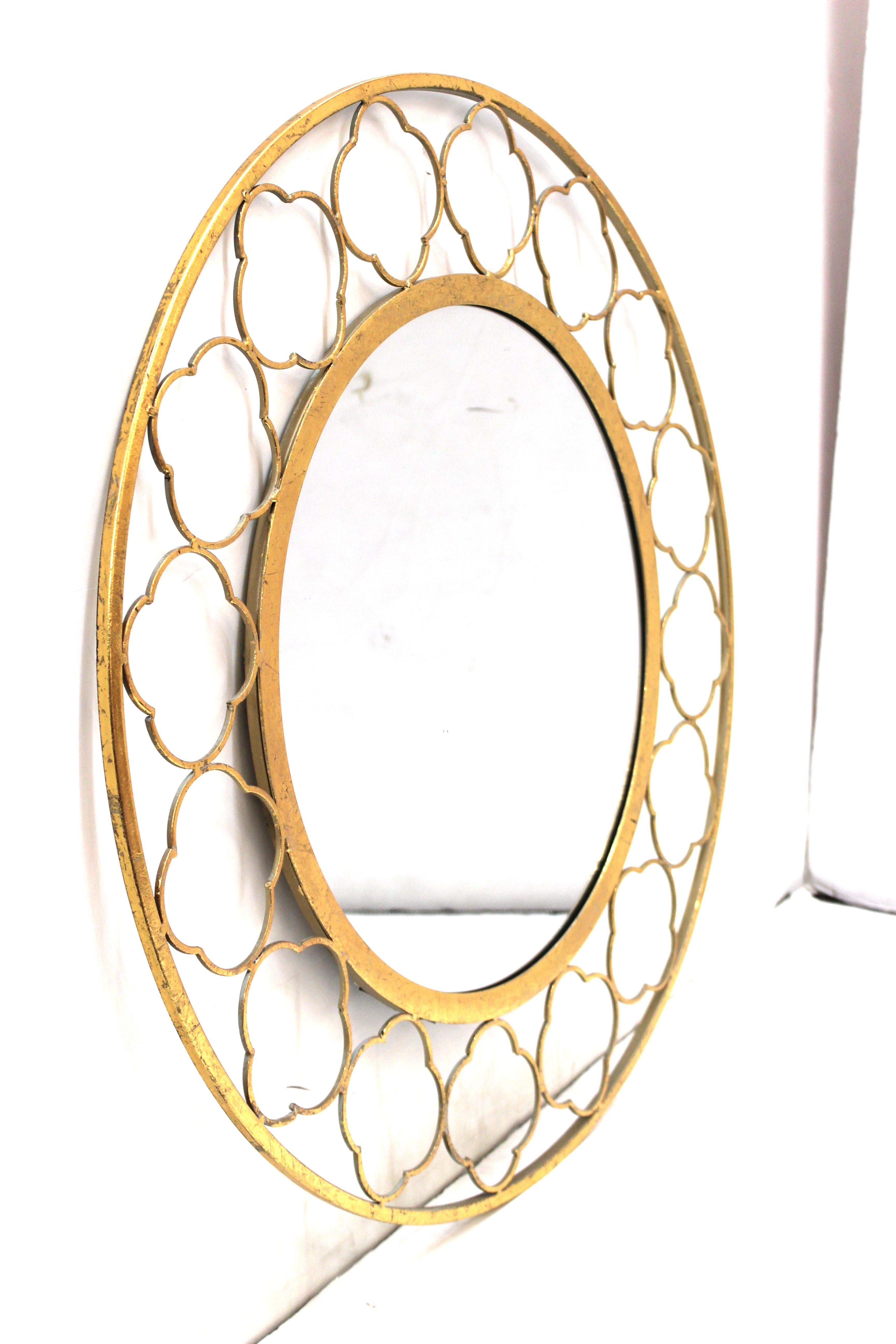 Mid-Century Modern style round gilt metal mirror with decorative quatrefoil border motif. The mirror is in good vintage condition.