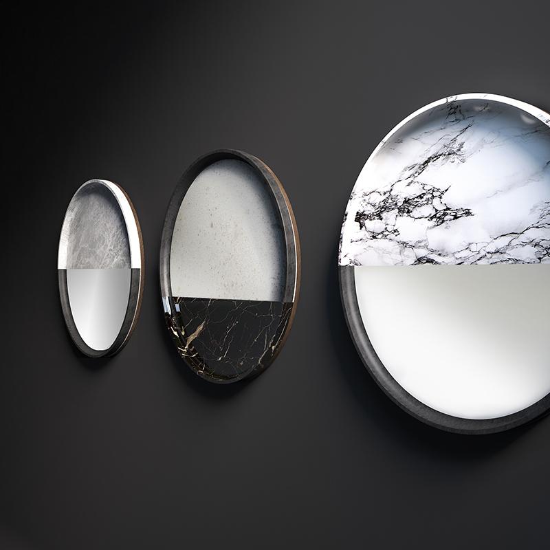 A range of mirrors where glass enhances marble and stone textures. Lightness and solidity, elusiveness and presence, lights and shadows: opposite attract in essential and surprising forms. Hung over dark or light walls, one after the other, the