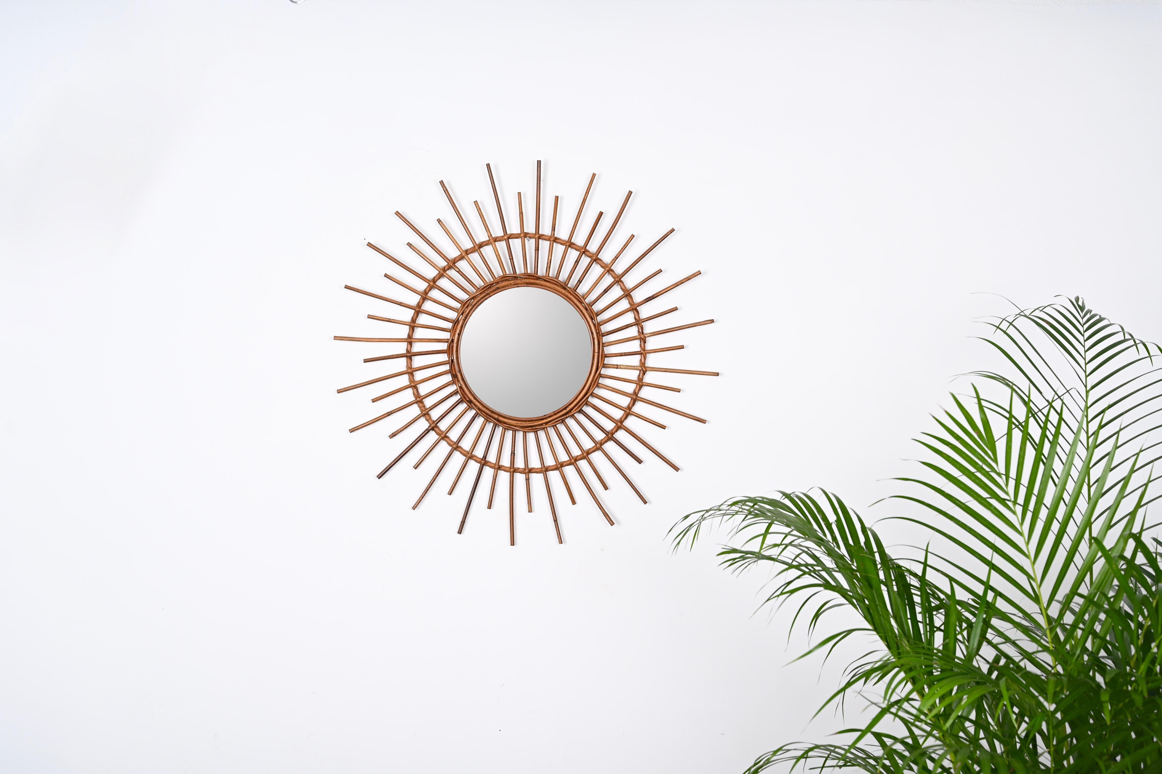 Gorgeous sun-shaped round mirror in curved rattan and bamboo. This stunning item was produced in Italy during 1960s.

This beautiful mirror features a double frame with fantastic rattan wicker weaves, the frames are decorated by straight rattan