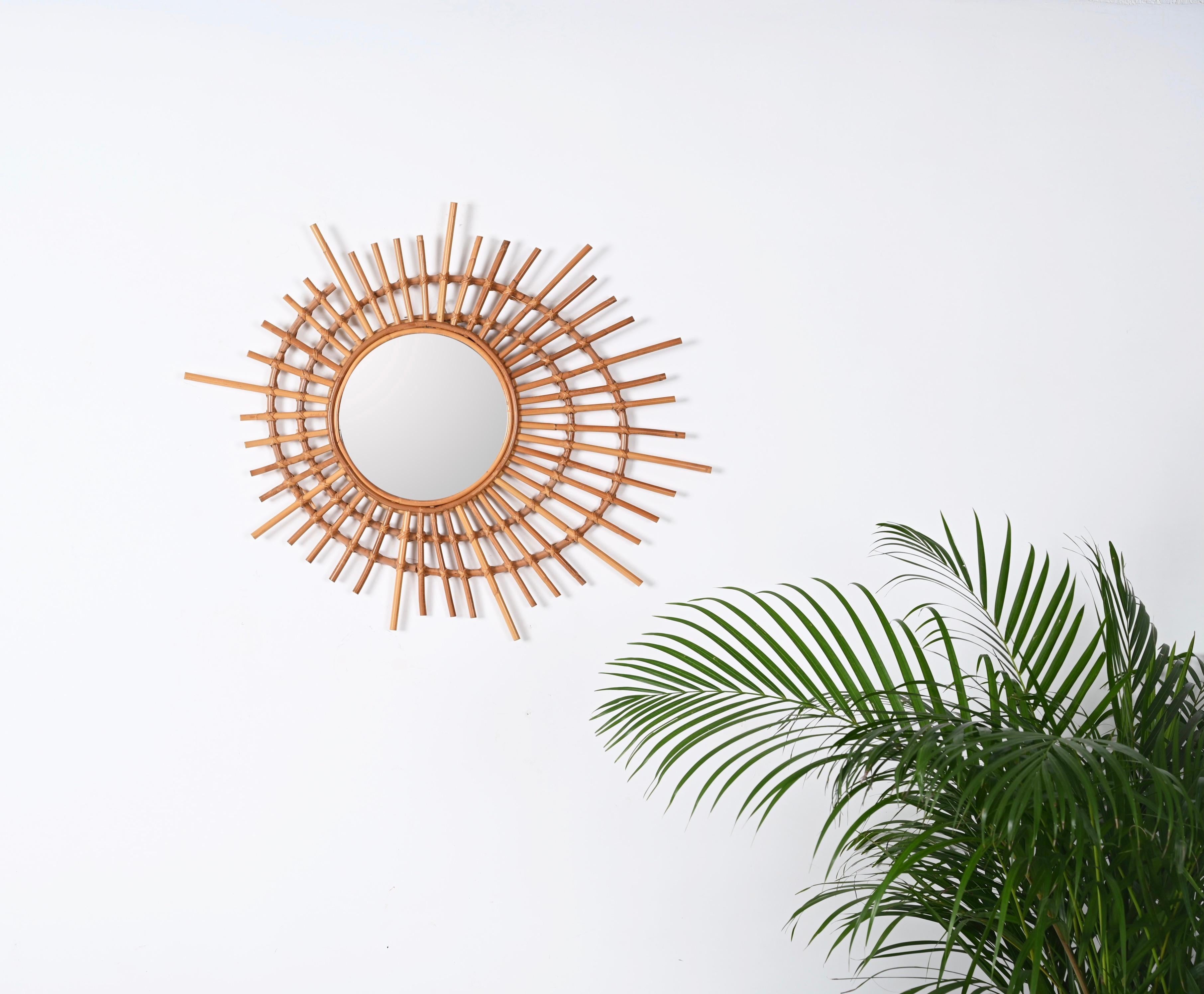 Gorgeous mid-century sun-shaped round mirror in curved rattan and bamboo. This lovelt piece was produced in Italy during 1970s.

This beautiful mirror consists of a stunning spiral-shaped frame in curved rattan decorated by straight rattan beams