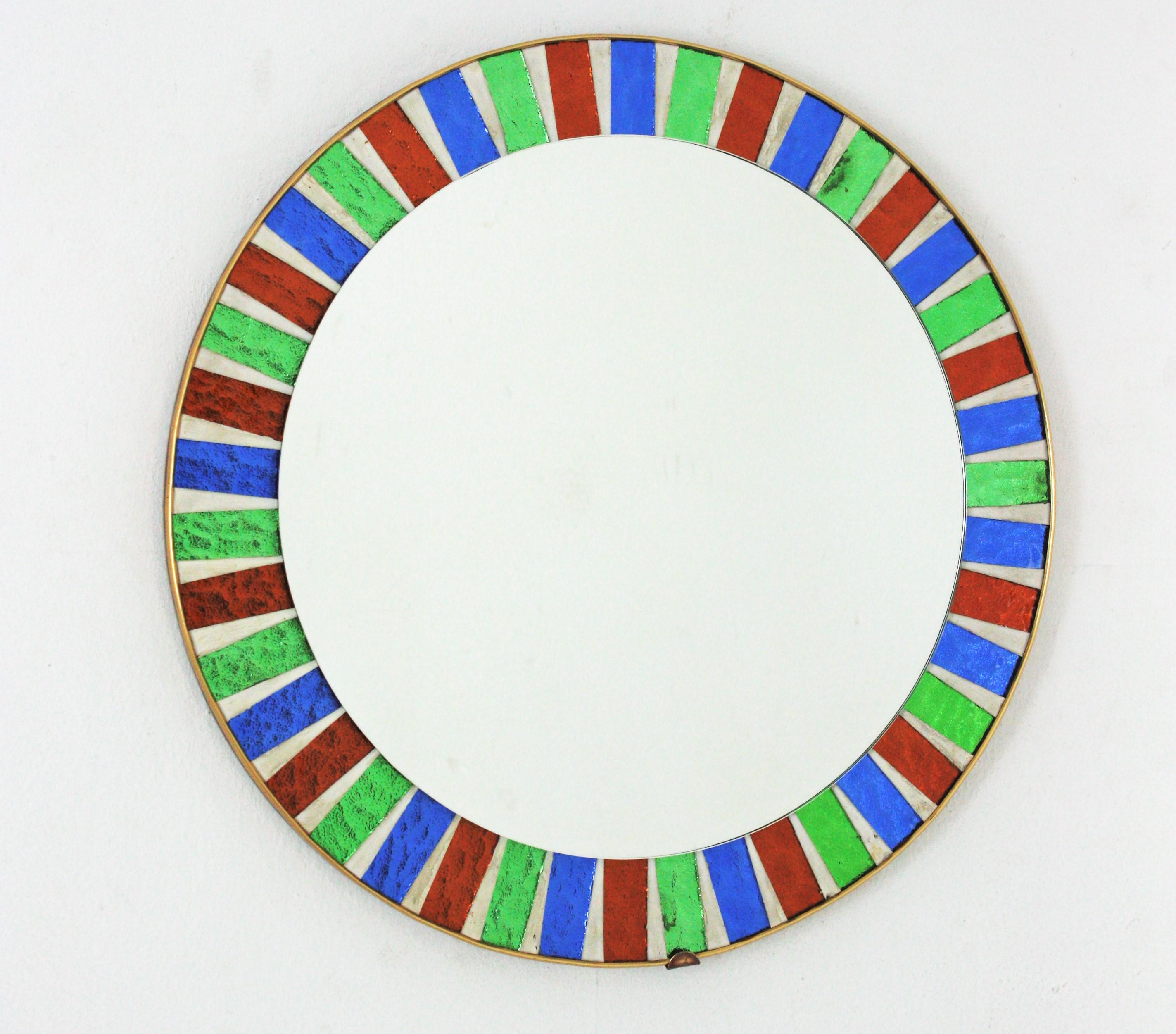 Midcentury Sunburst Round Mirror with Green Blue Red Glass Mosaic Frame

Colorful Midcentury sunburst mirror with red, blue and green glass mosaic frame Spain, 1950-1960s.
This mirror features a beautiful round mosaic frame with alternating red,