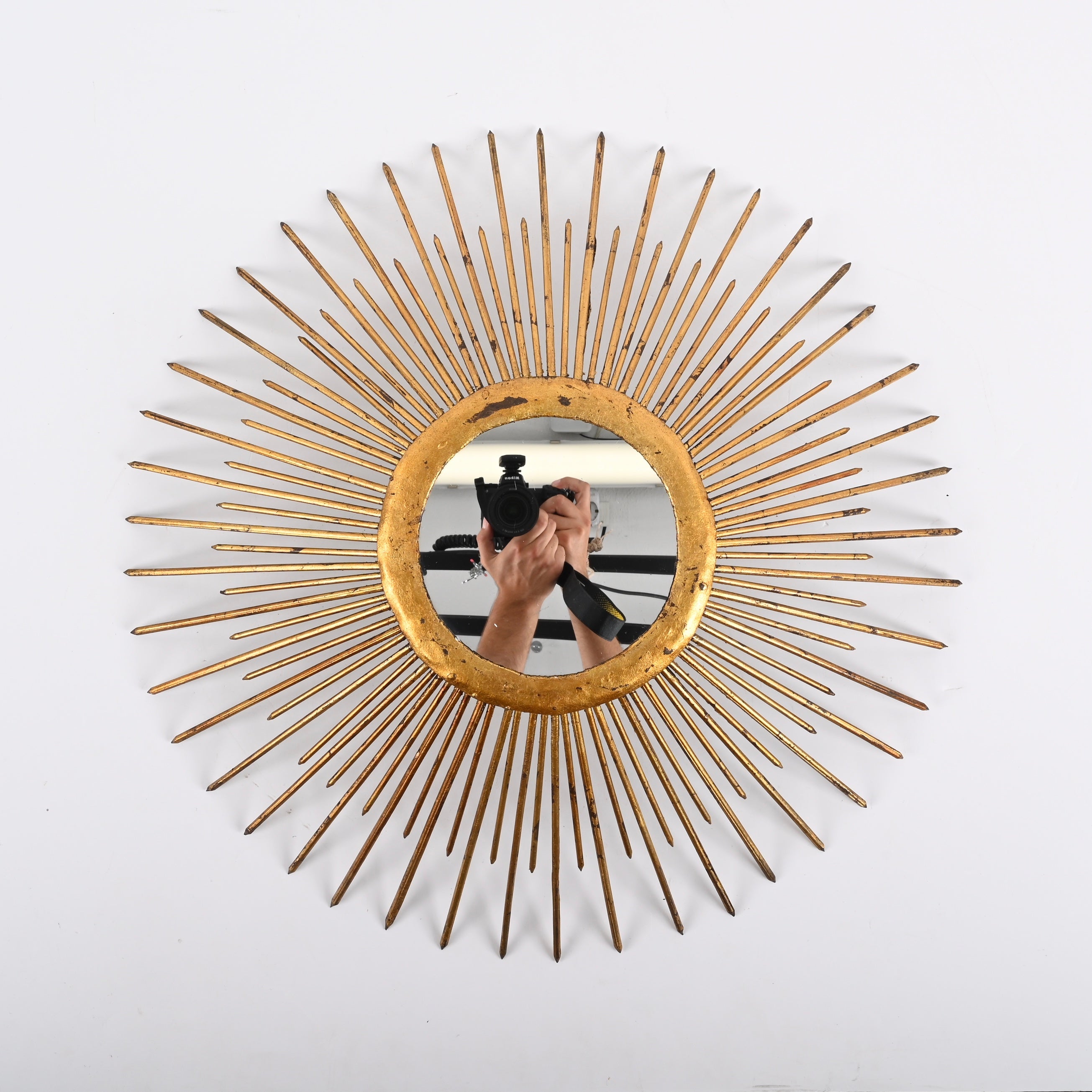 Stunning vintage sun shaped mirror. The structure is in gilden iron, with the particularity of having a lighting system on the rear that can light up the mirror from the back, giving a wonderful effect on the wall.
The mirror was produced in Italy