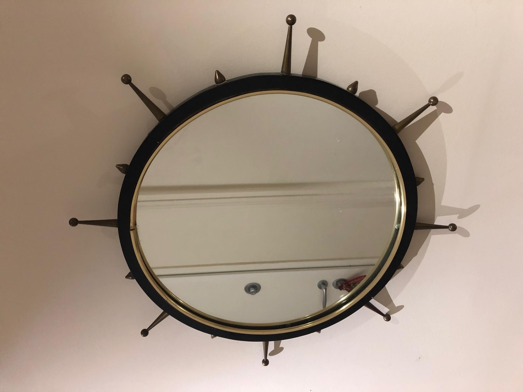 Round metal mirror from the 1950s with brass spikes
Original condition.