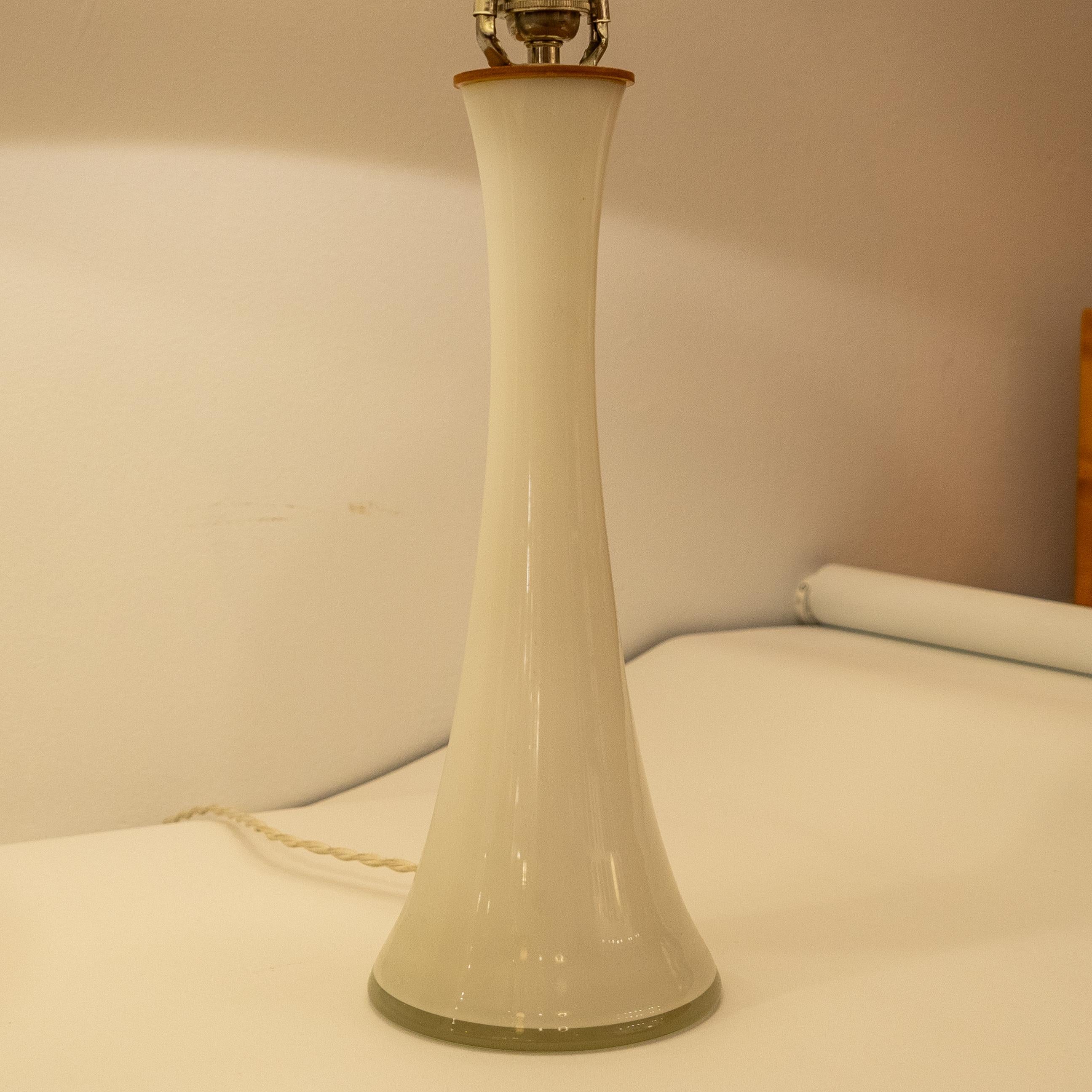 Add a touch of mid-century modern style to your bedroom with this pair of Swedish bedside lamps. Made of hand-blown glass from the southern region of Sweden, these lamps feature a unique tapered design and have been rewired for use in the United
