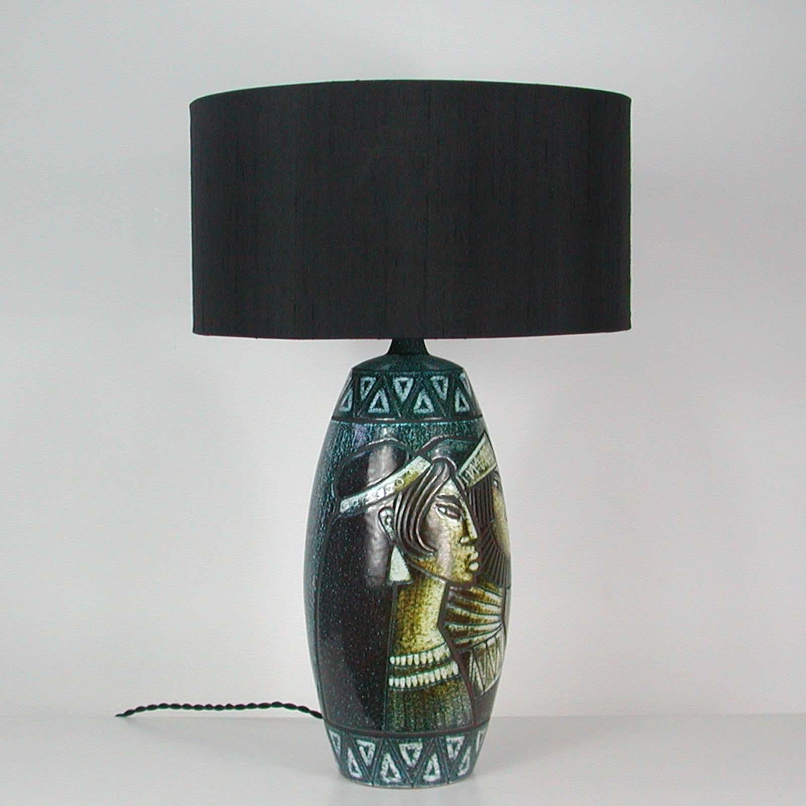 This large and elegant Scandinavian Modern table lamp was designed and manufactured in Sweden in the 1960s. Design Bonnie Rehnkvist, Törngrens for Falkenbergs Belysning. Signed.

It has got a dark blue or black or cream ceramic base.

The lamp