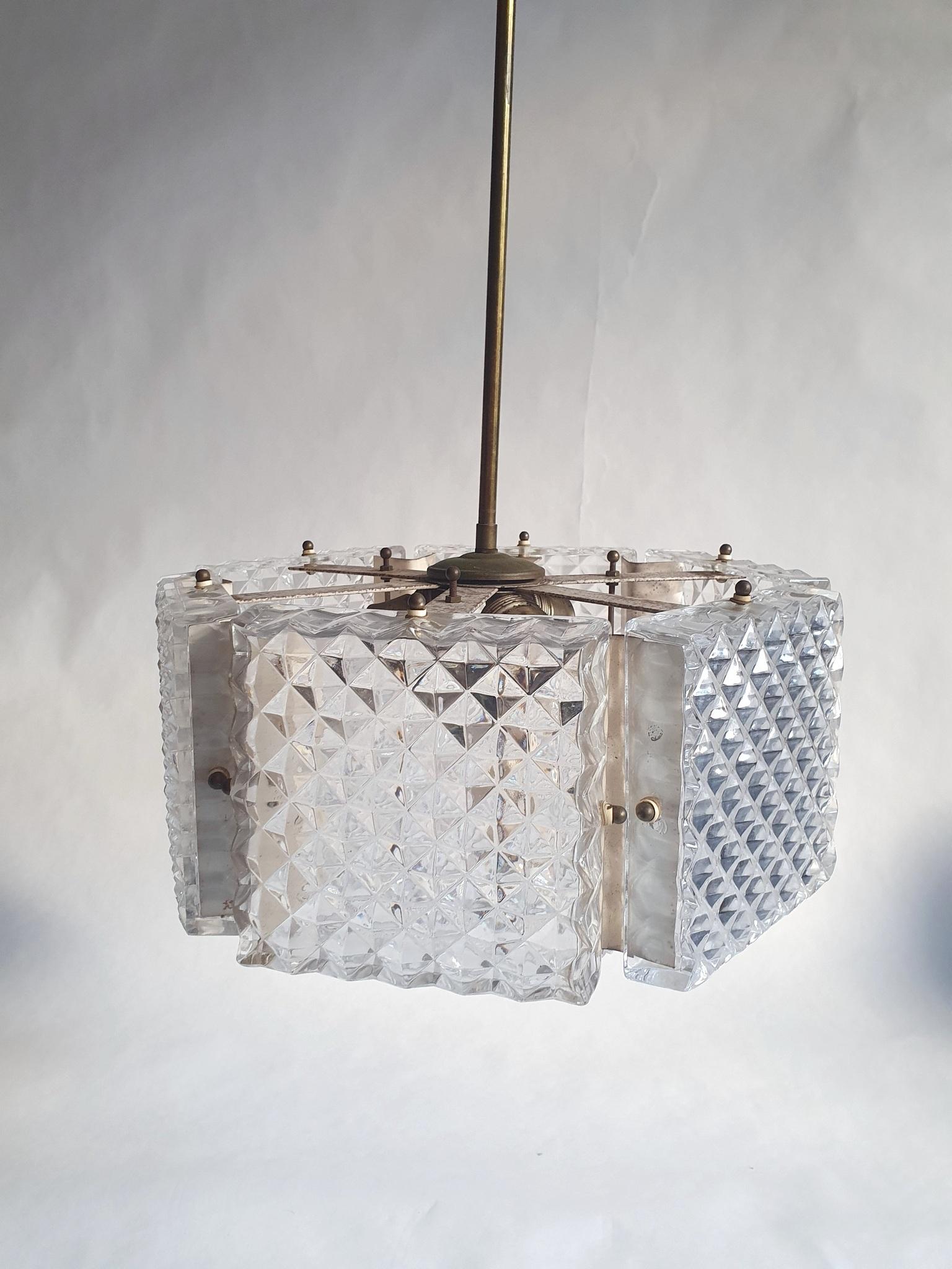 An unusial hexagon pendan in clear glass, , by the world renowned Swedish glass maker Orrefors. The chandelier has a particular design consisting of six squares set in a hexagon shape with a pattern a bit similar to Belgian waffles. The bottom of