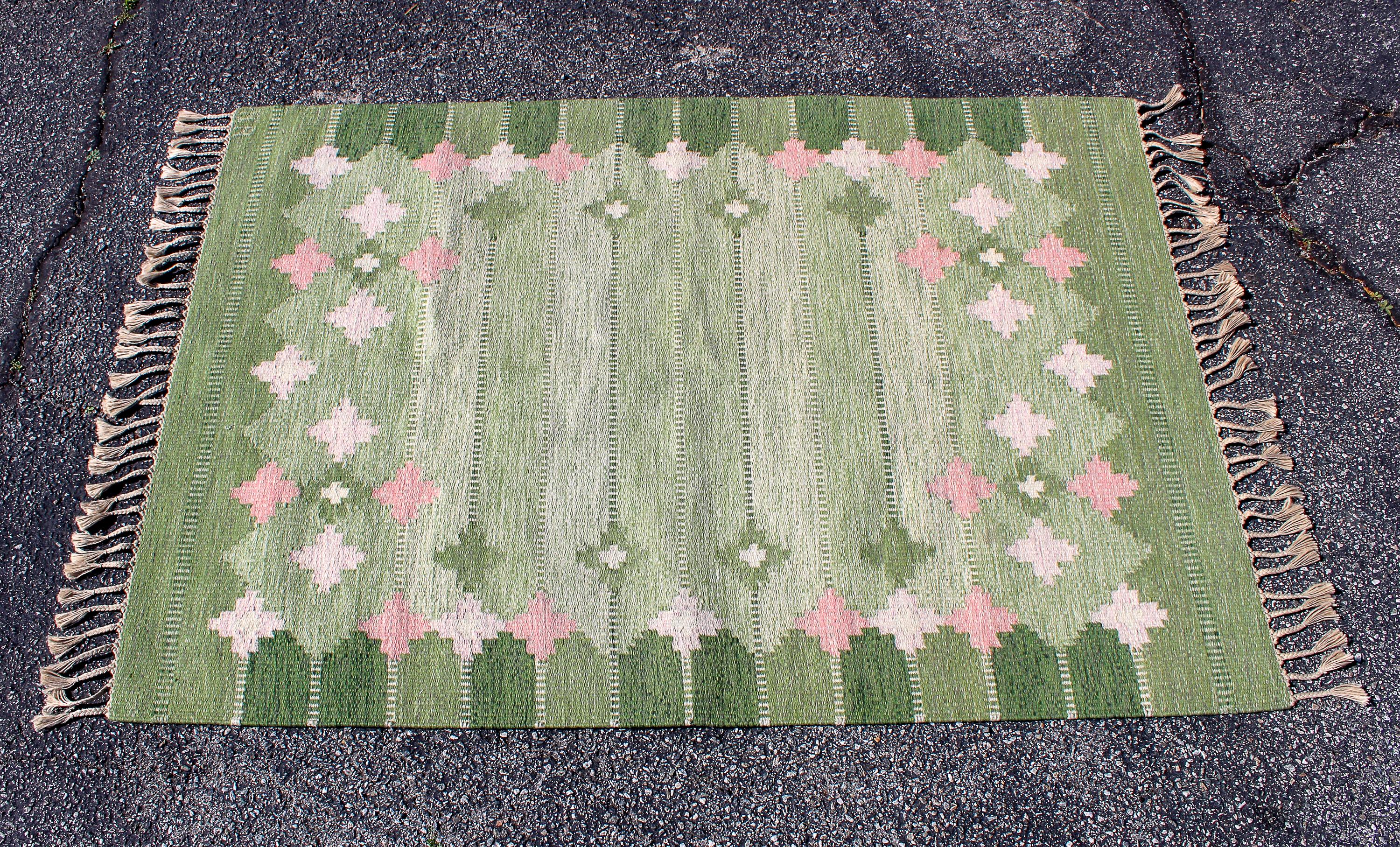 A midcentury Swedish flat-weave carpet (Röllakan) with a green base and geometrical patterns. The carpet is signed AB. Very good vintage condition with signs of usage consistent with age and use.