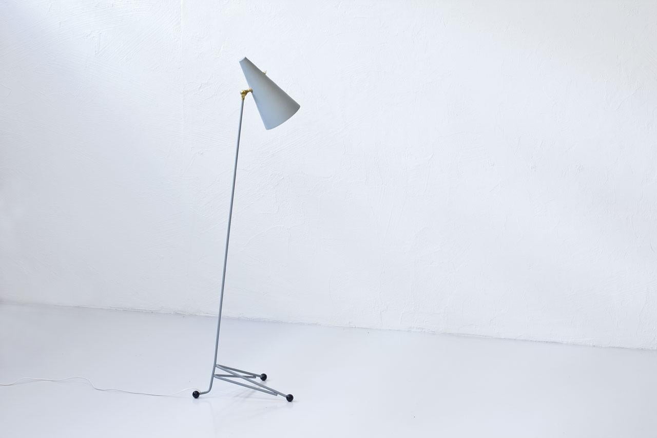 Swedish floor lamp, manufactured during the 1950s. Metal stem, aluminum shade. Grey lacquer finish. Adjustable reflector with brass fitting. Light switch on shade in working condition.