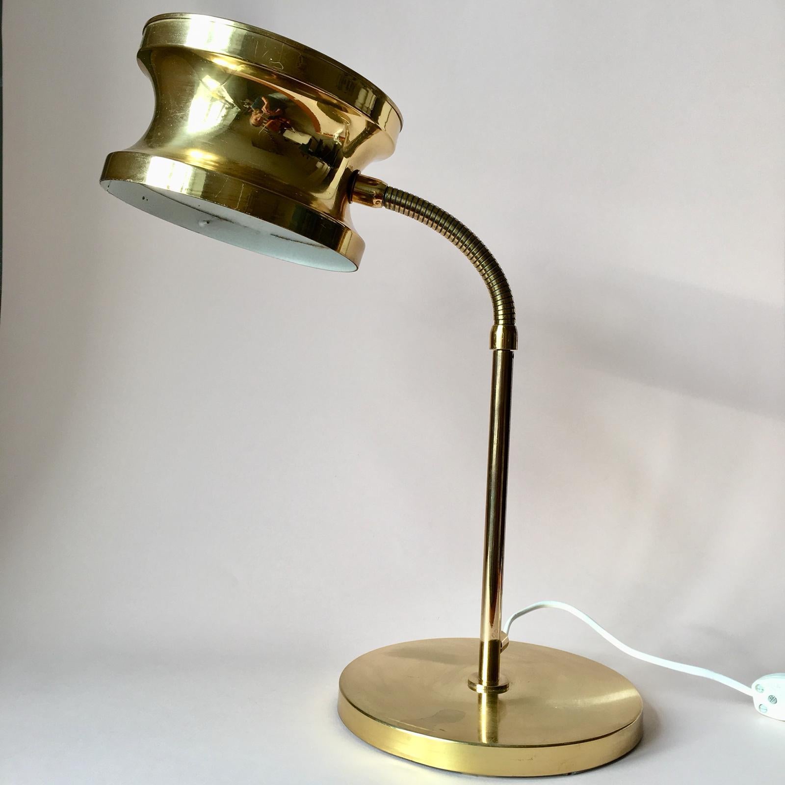 This vintage desk lamp is fully made of brass with white color inside the shade. Due to its brass bending arm you can change a light angle and its height. The brass parts are in a good vintage condition, but the white inside part features some signs