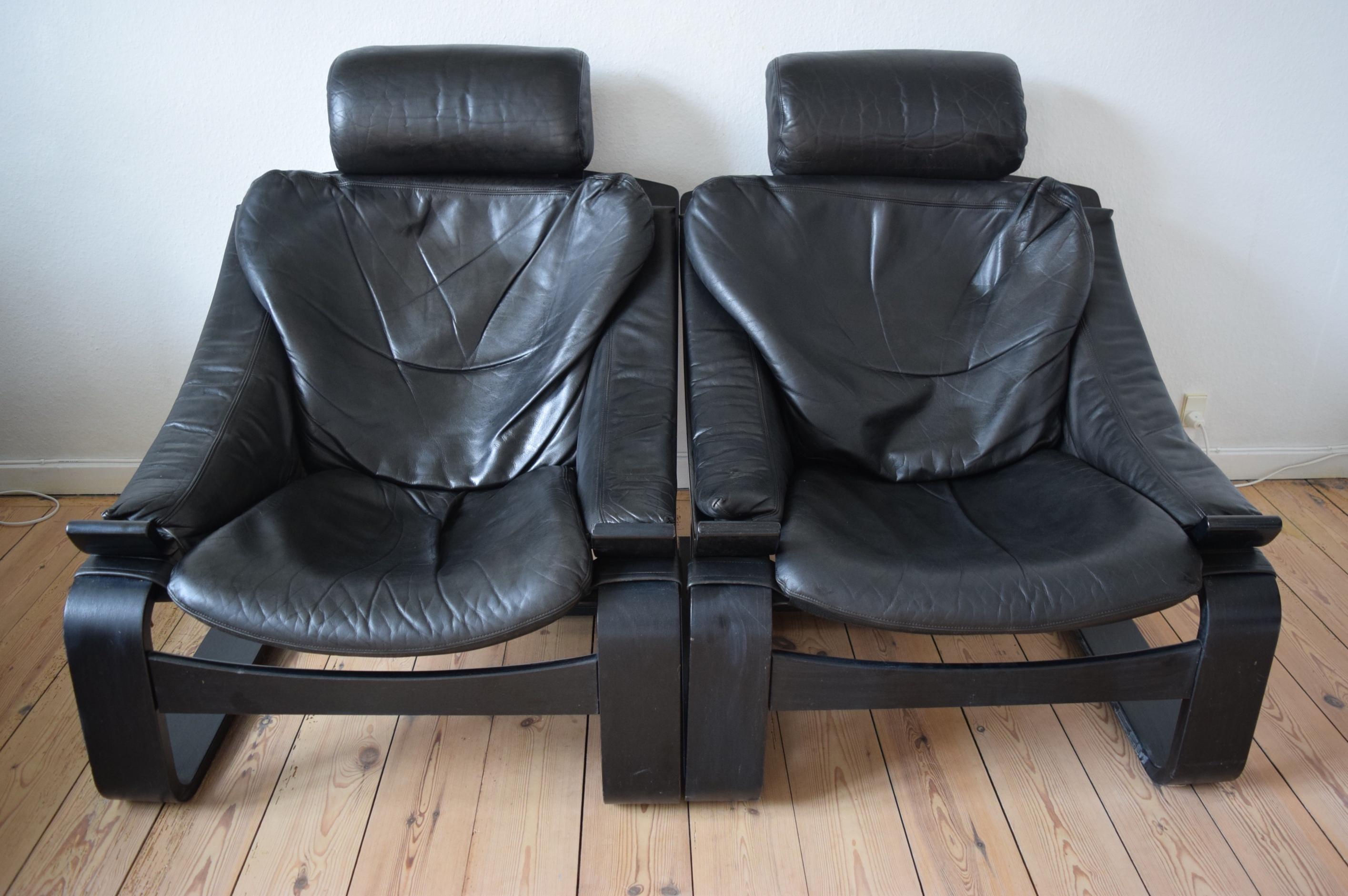 Pair of Swedish lounge chairs, designed by Åke Fribyter for Nelo in 1974, features a structure in painted black beechwood and seats in black padded leather. They have an adjustable headrest and details in leather.
  