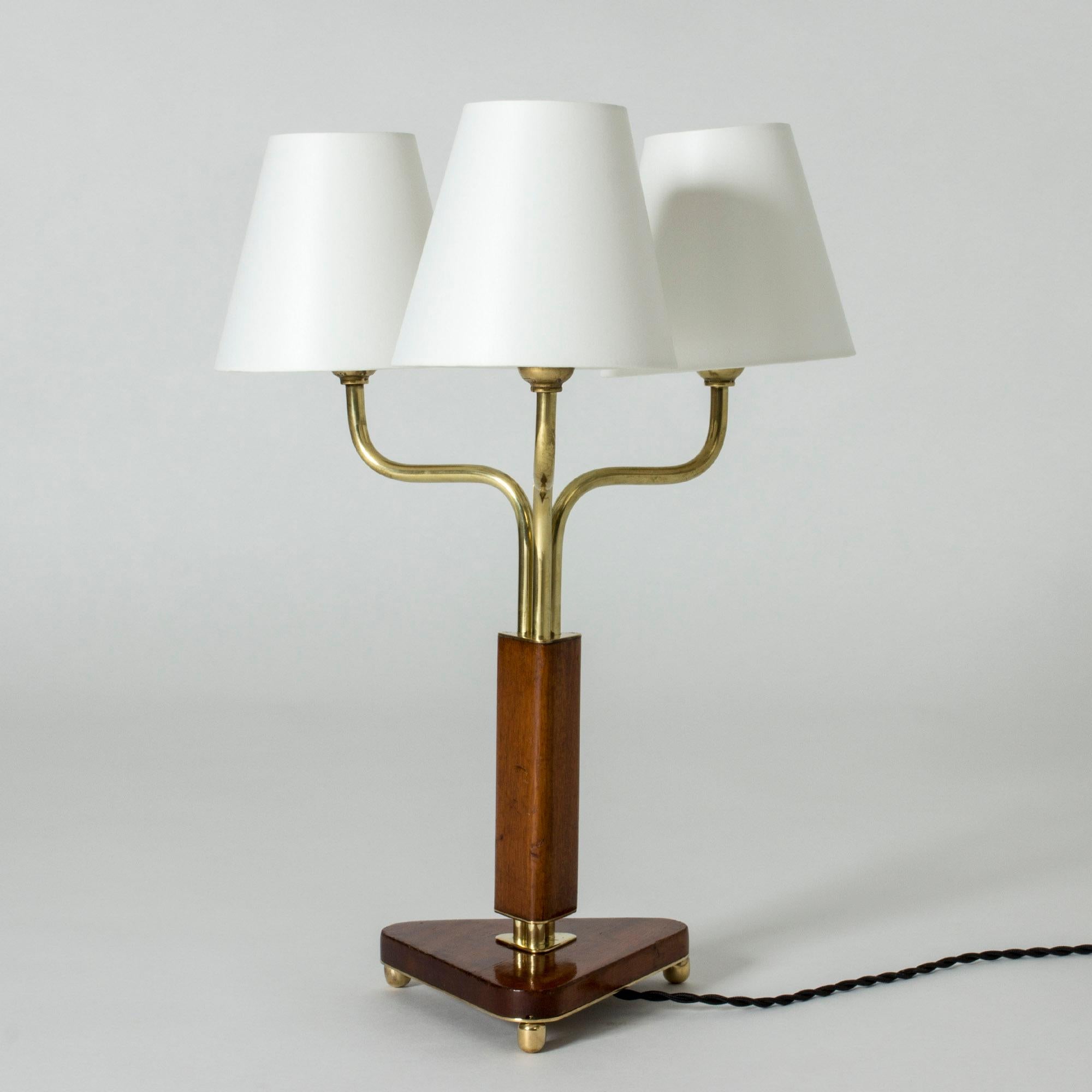 Mahogany and brass table lamp, made in Sweden in the 1940s. Three shades on arched arms. Beautiful mahogany stem and triangular base with brass ball feet.