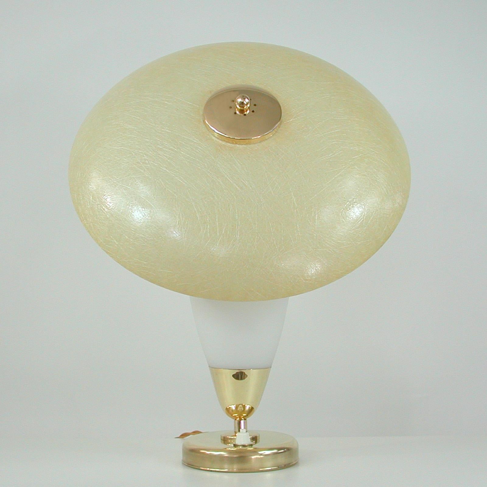 This unusual midcentury table lamp was designed and manufactured in Sweden in the 1950s to 1960s. 

This is a very stylish and dynamic atomic piece in the style of Greta Grossmans reflector designs of the 1950s.

The lamp features a brass base,