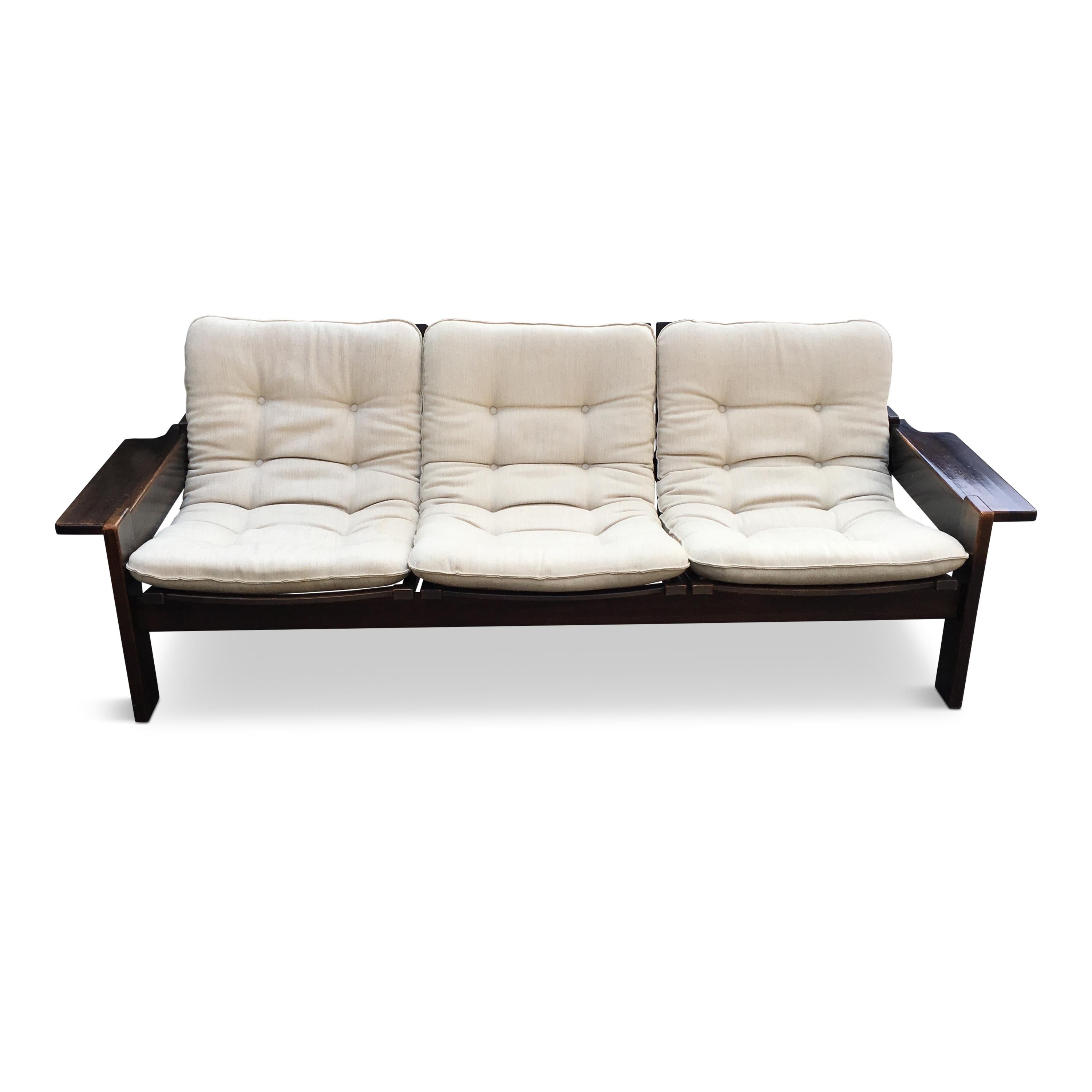 Modernist form, dark wood, the armrests can be used as side tables.

Fully original condition – white/beige wool upholstery (needs to be reupholstered because of stains), each pillow has a frame inside (heavy). The wood has been