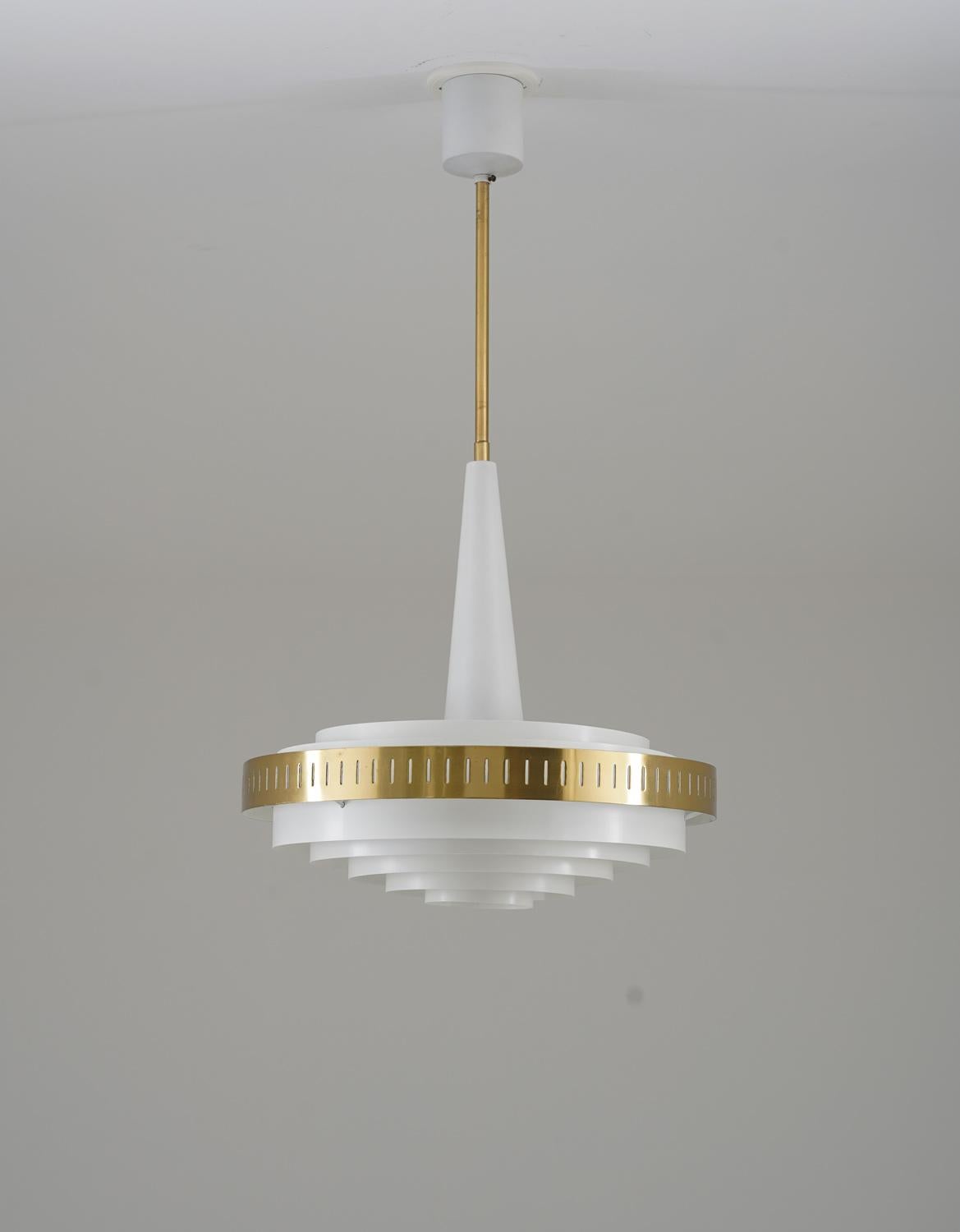 A beautiful pendant in metal and brass, probably manufactured by Boréns, Sweden, 1960s.
The lamp features one light source, surrounded by metal rings and one perforated brass ring, giving a nice soft light.

Condition: Very good condition,
