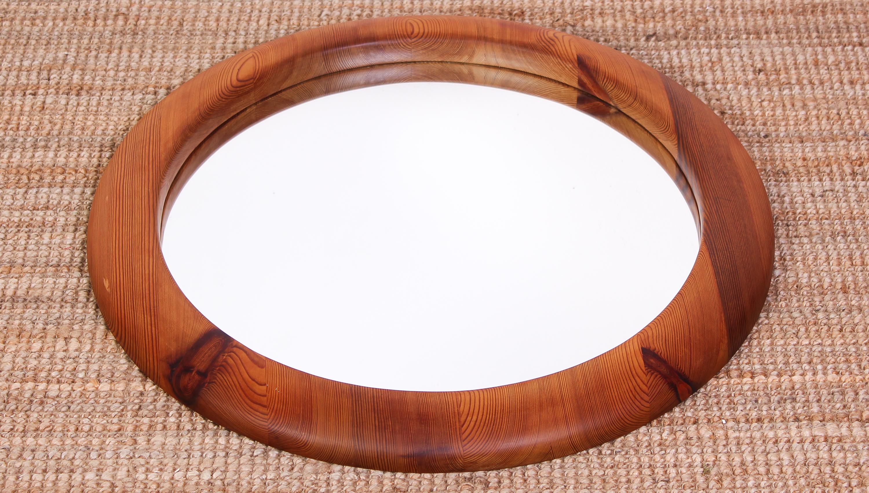 A large round mirror made in Sweden during the 1960s. The frame is made out of solid pine of high quality. Great grain in the wood and nicely sculptured. Very good vintage condition with minor signs of usage.