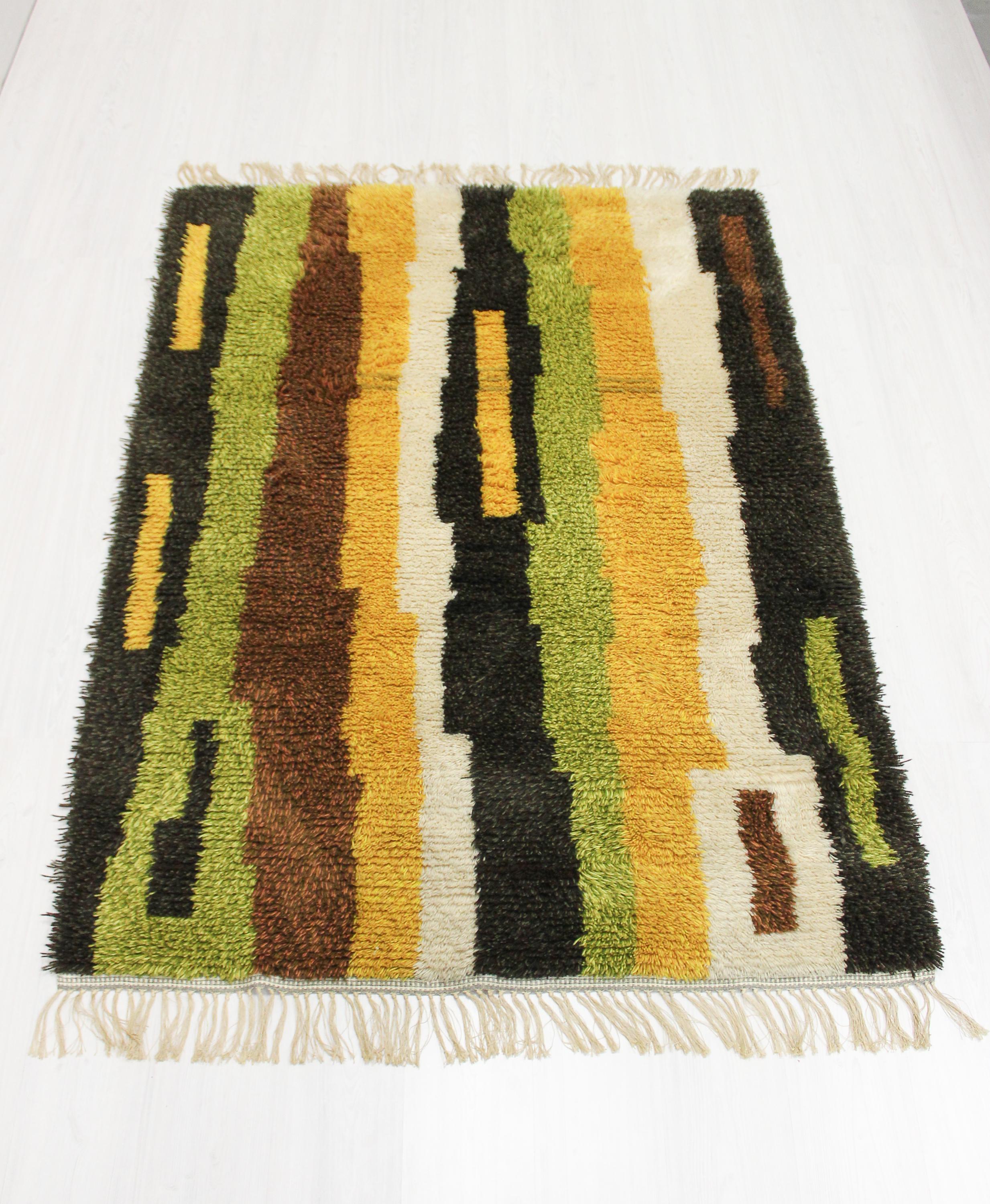 A very decorative Swedish rya rug from the 1960s. A beautiful color pallet and abstract design. Very good vintage condition with minor signs of usage.