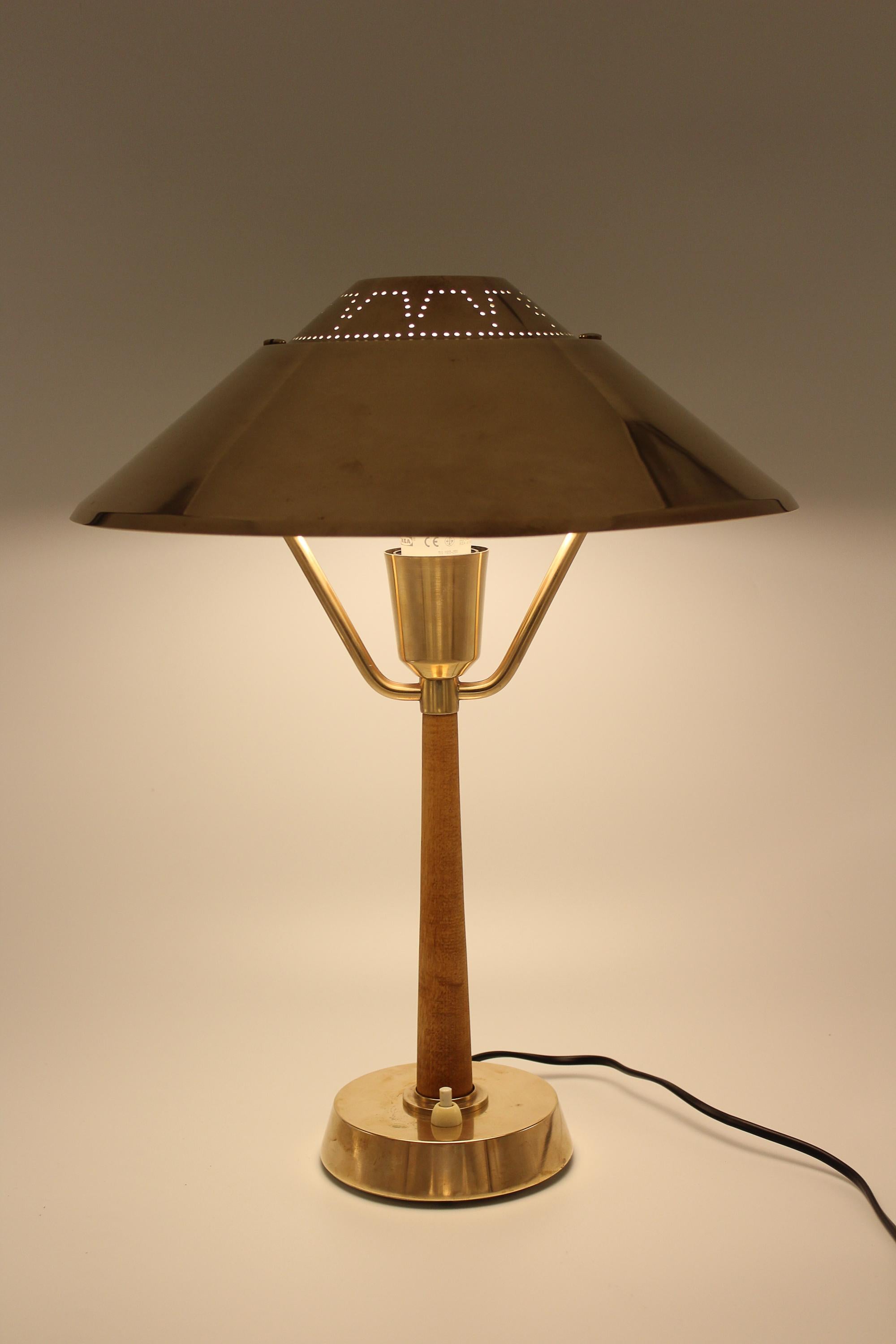 A midcentury table lamp by manufacturer AB E Hansson from Malmö, Sweden. The lamp was produced in the 1940s and is made out of brass and stained beech. Very good vintage condition with patina consistent with age and rewired.