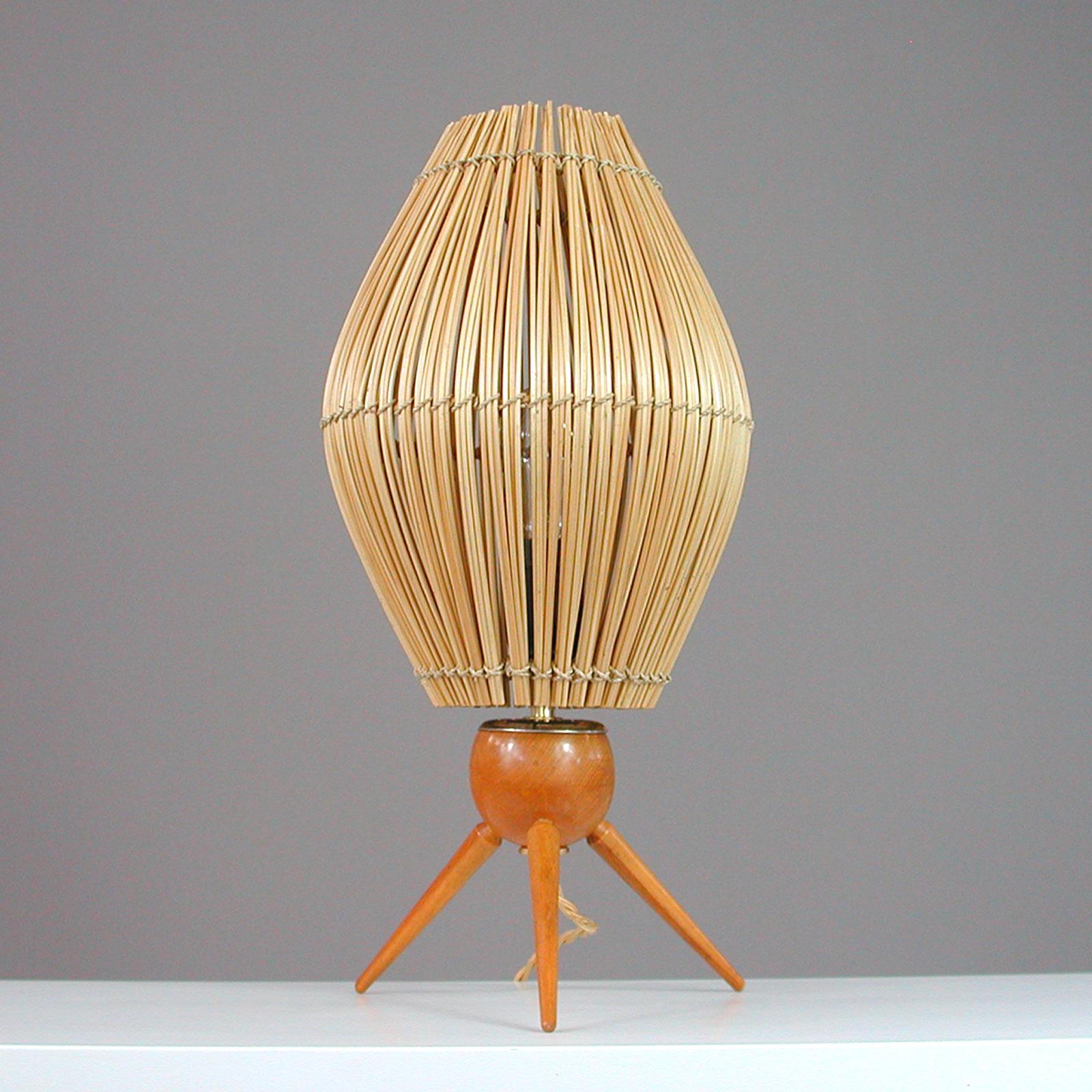 This large and elegant Scandinavian Modern table lamp was designed and manufactured in Sweden in the 1950s. It features a teak tripod base with a rattan conical lampshade and requires one E27 bulb.

An awesome design with period style tapered teak
