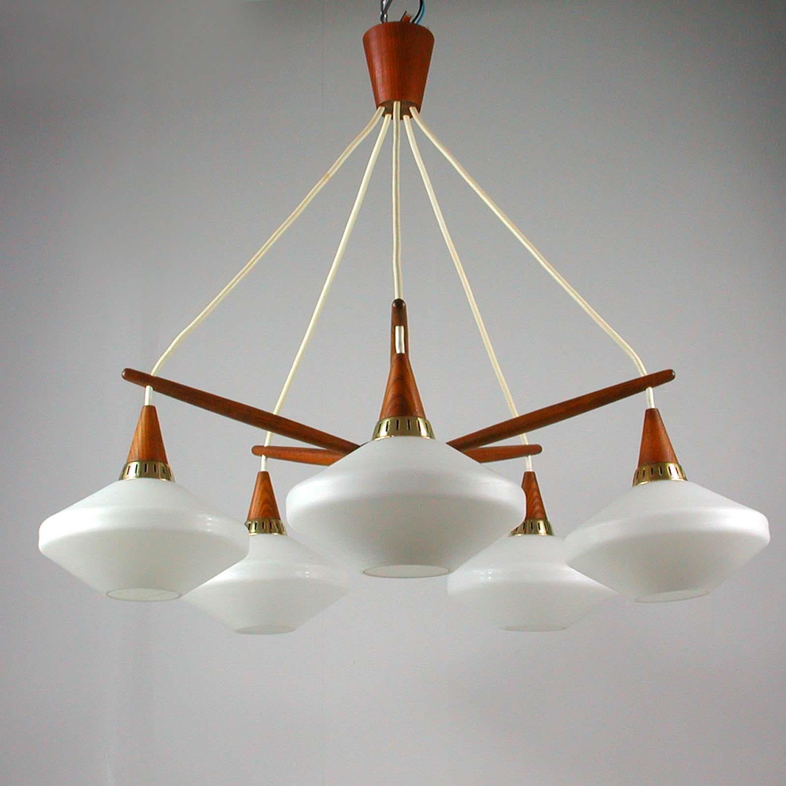 This elegant five-light chandelier was manufactured in Sweden by ASEA in the late 1950s-early 1960s and attributed to Hans Bergström. It is made of teak and has got five satin opal glass lampshades with brass details.

Condition is very good and