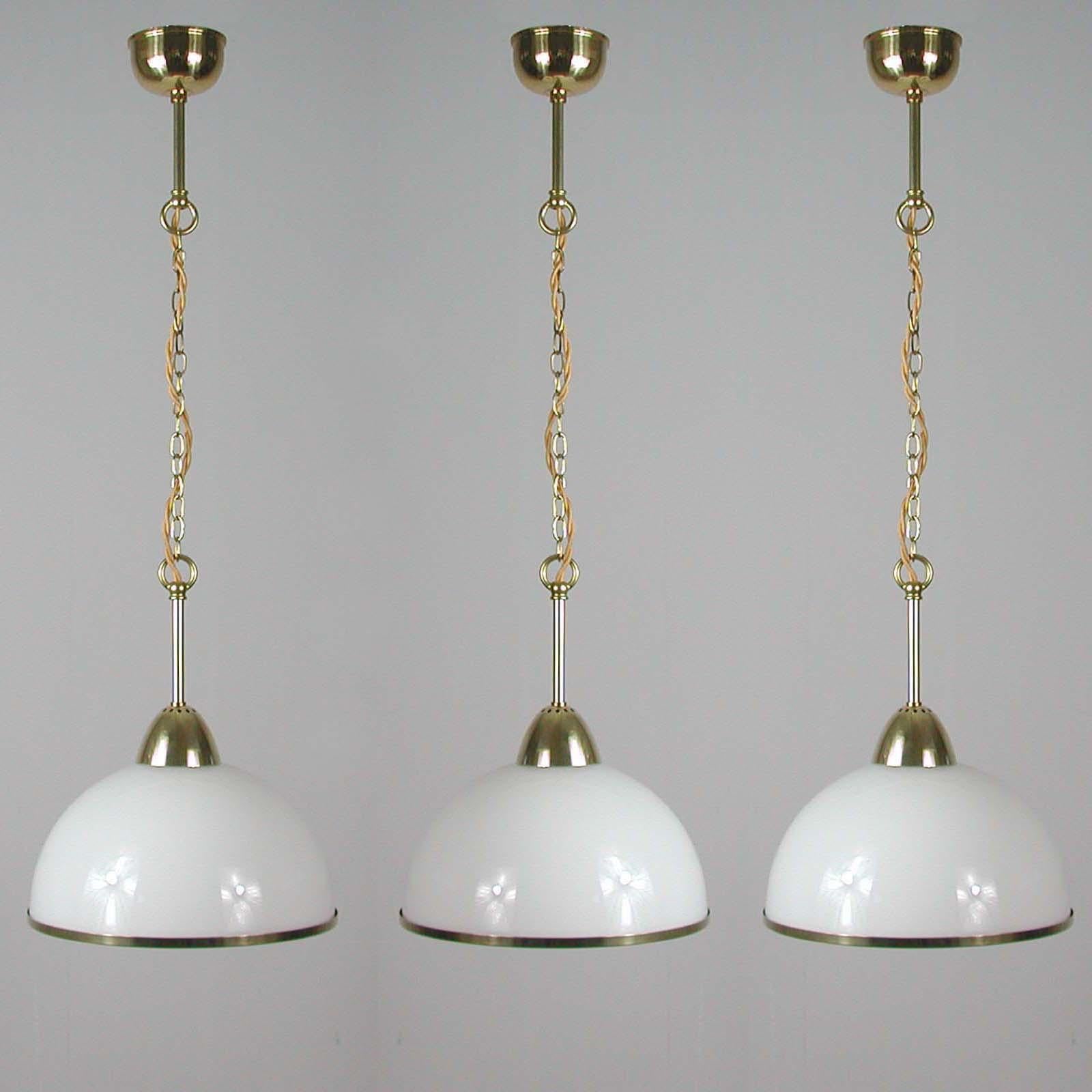 This elegant midcentury pendant was designed and made in Sweden in the 1950s. The light features a white opaline glass lampshade and brass hardware. Good vintage condition with one E27 socket per lamp.

The lamps have been rewired for use in US