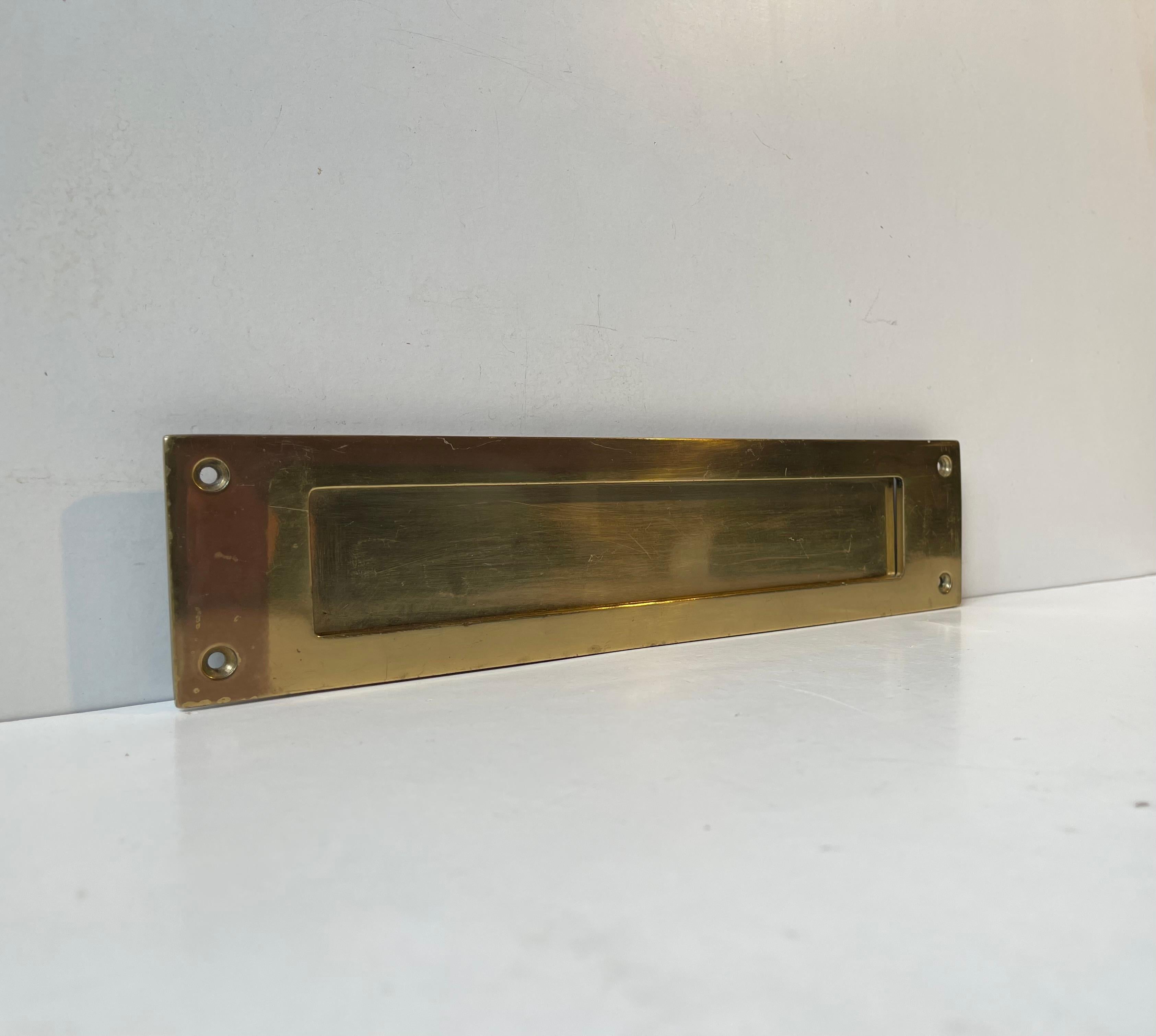 A wide - large scale door letter slot/plate in solid brass. Un-polished but well-kept vintage condition and mechanically sound and steady. Large enough for newspapers, large thick letters and small books. Made by Gamleby Norden in Sweden circa