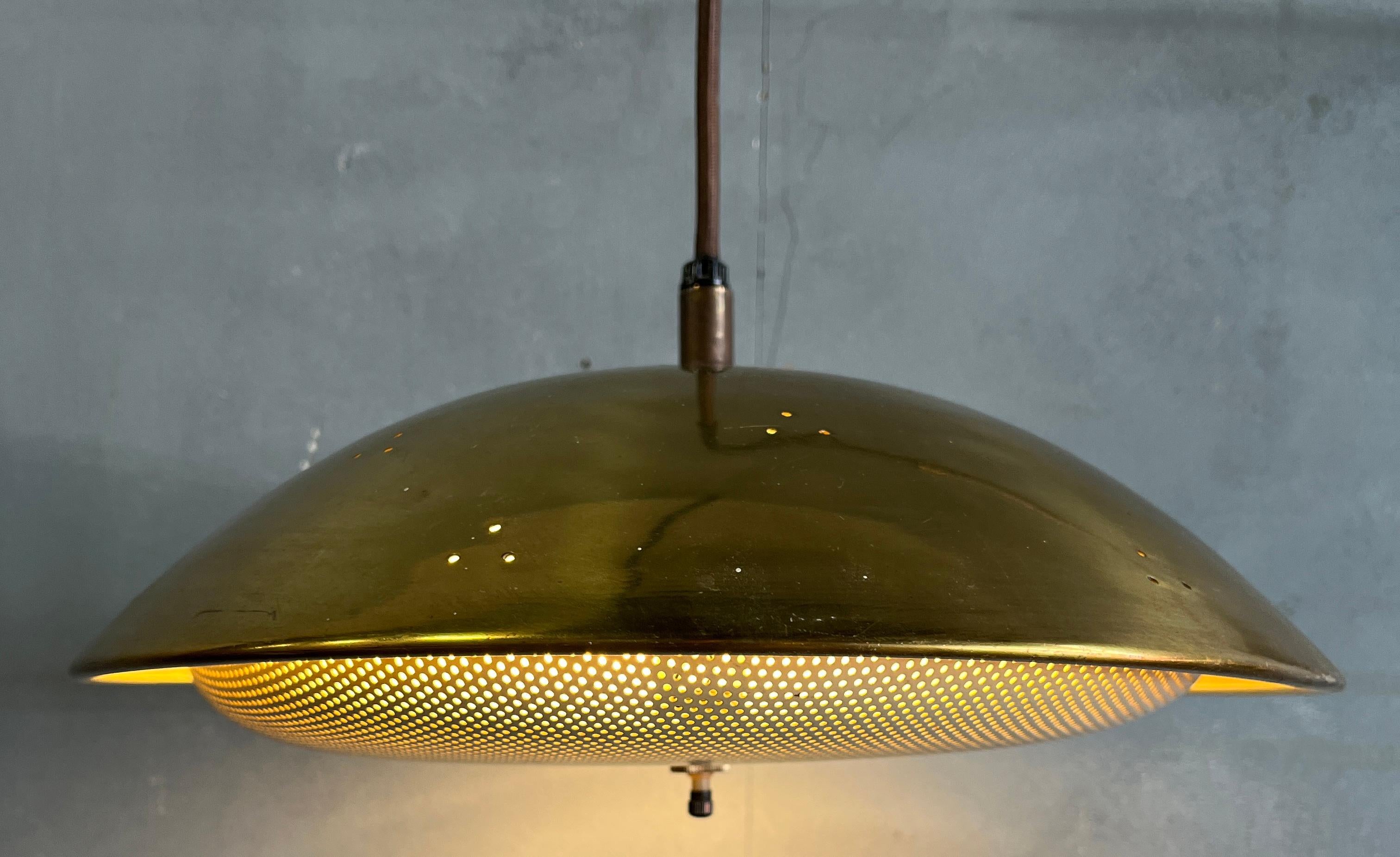 Beautiful swing arm adjustable wall lamp with brass perforated shade. Adjust from 20'' to around 29'' in width. Height can be adjusted by a counterweight on the cord.
Perfect reading lamp or accent light. 
New wiring. Body in original condition
