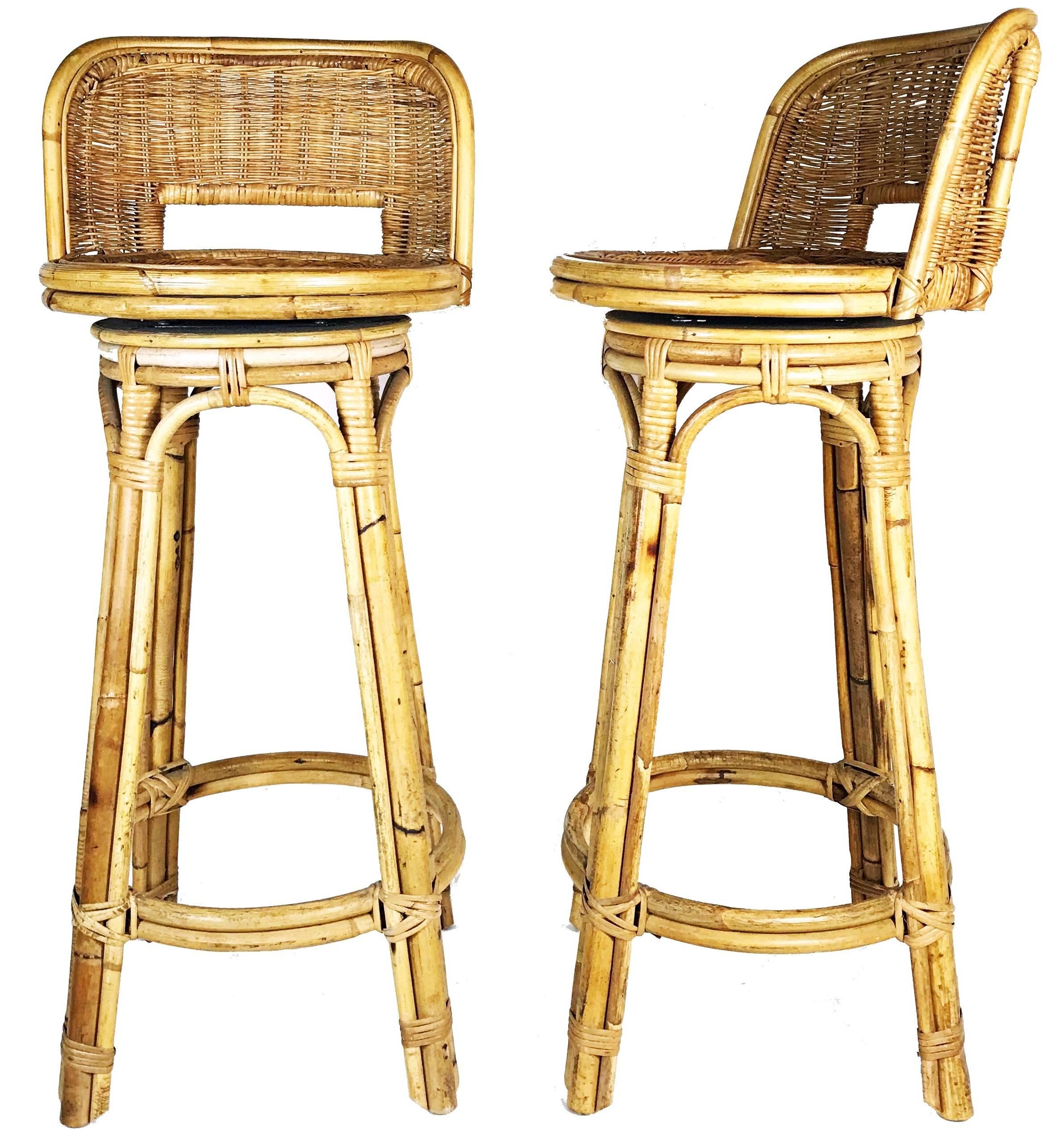Pair of rare rattan bar stools in style of Paul T. Frankl from 1950s - epic set that will look fabulous in any space. The stools feature thick bamboo frames and comfortable rattan seats conveniently swivel for ease of use. Overall good vintage