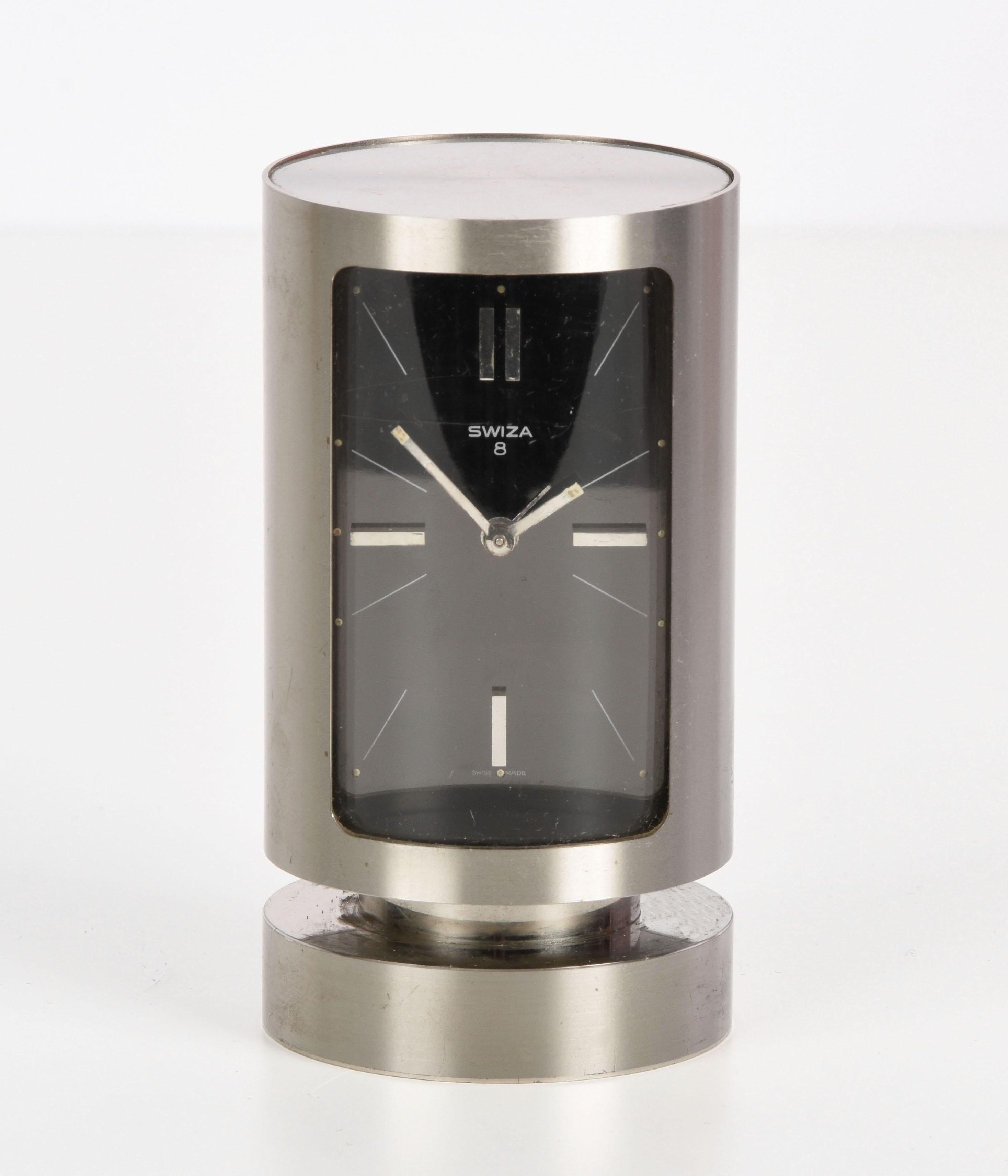 Very elegant Midcentury Swiza with 8-day movement and 1960s alarm clock. This amazing piece was designed in Switzerland during the 1960s.

 This wonderful heavy chrome cylinder-shaped case table clock has a black dial with large and small chromed