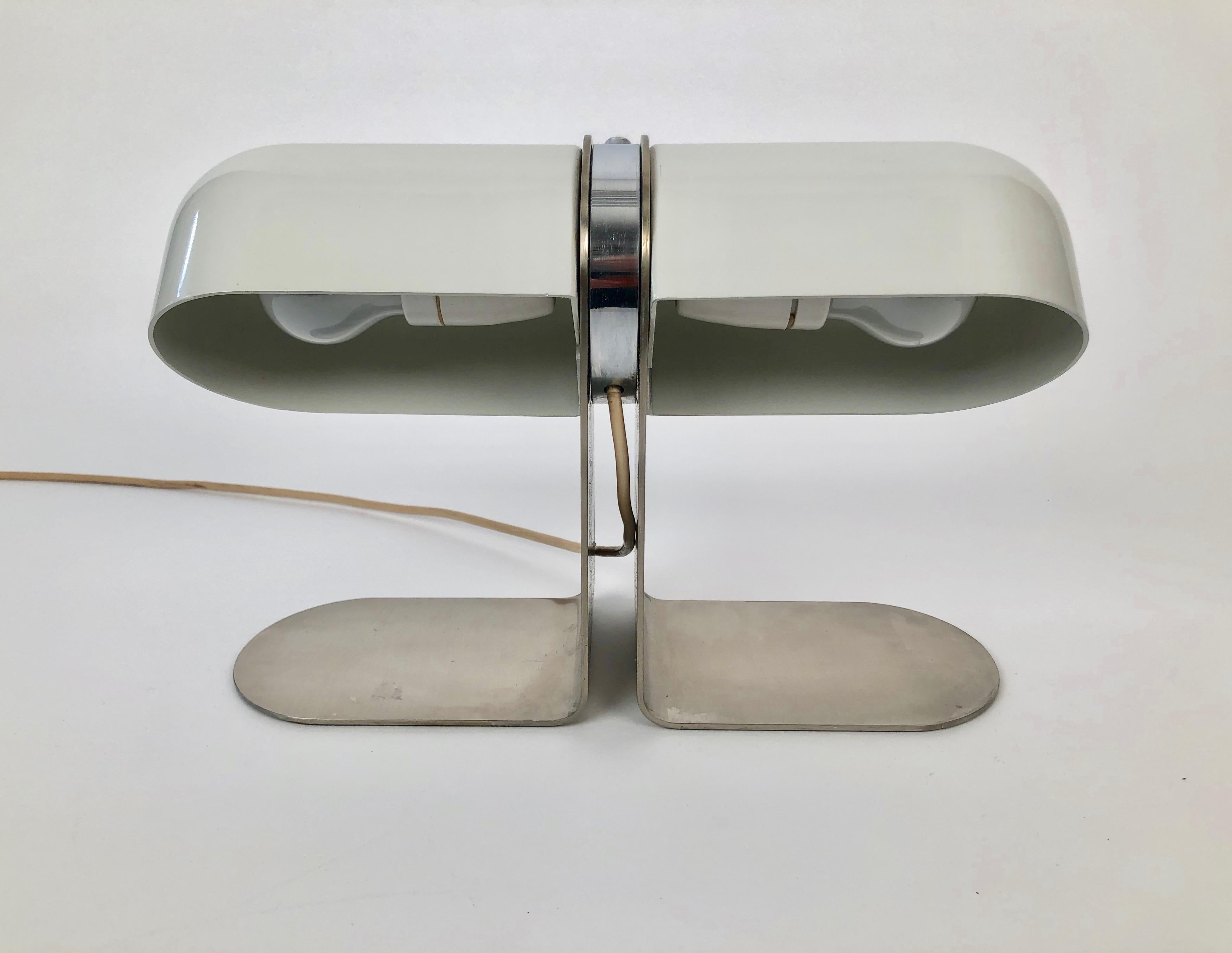 Eine Tischleuchte, entworfen von Andre Ricard für Metalarte in Spanien, aus den 1970er Jahren.

Diese Ganzmetallleuchte besteht aus zwei drehbaren Metallschirmen, die an einem runden verchromten Mittelstück mit einem montierten Schalter befestigt