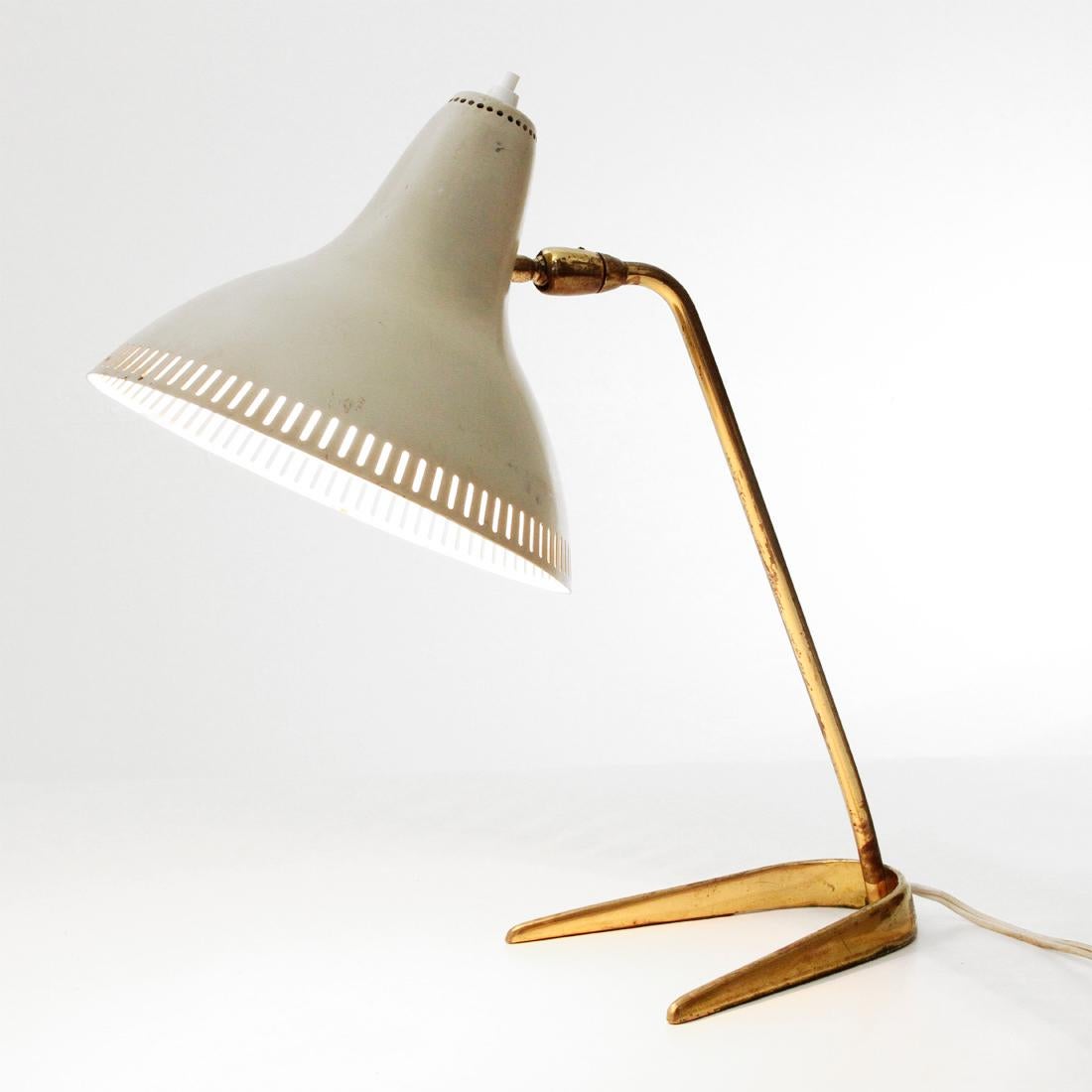 Table lamp produced in the 1950s.
Brass structure with horseshoe base.
White painted aluminum diffuser with decorative holes.
Good general conditions, some signs due to normal use over time.

Dimensions: Height 38 cm, diameter 20 cm, depth 35