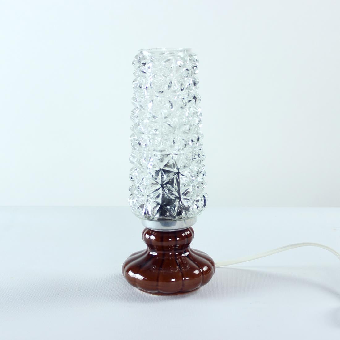 Beautiful table lamp produced in Czechoslovakia in 1960s. Produced in two amazing materials - ceramic base and glass shade. The base is made in brown glazed ceramics, shows no wear or tear, excellent condition. The shade is made in pressed glass