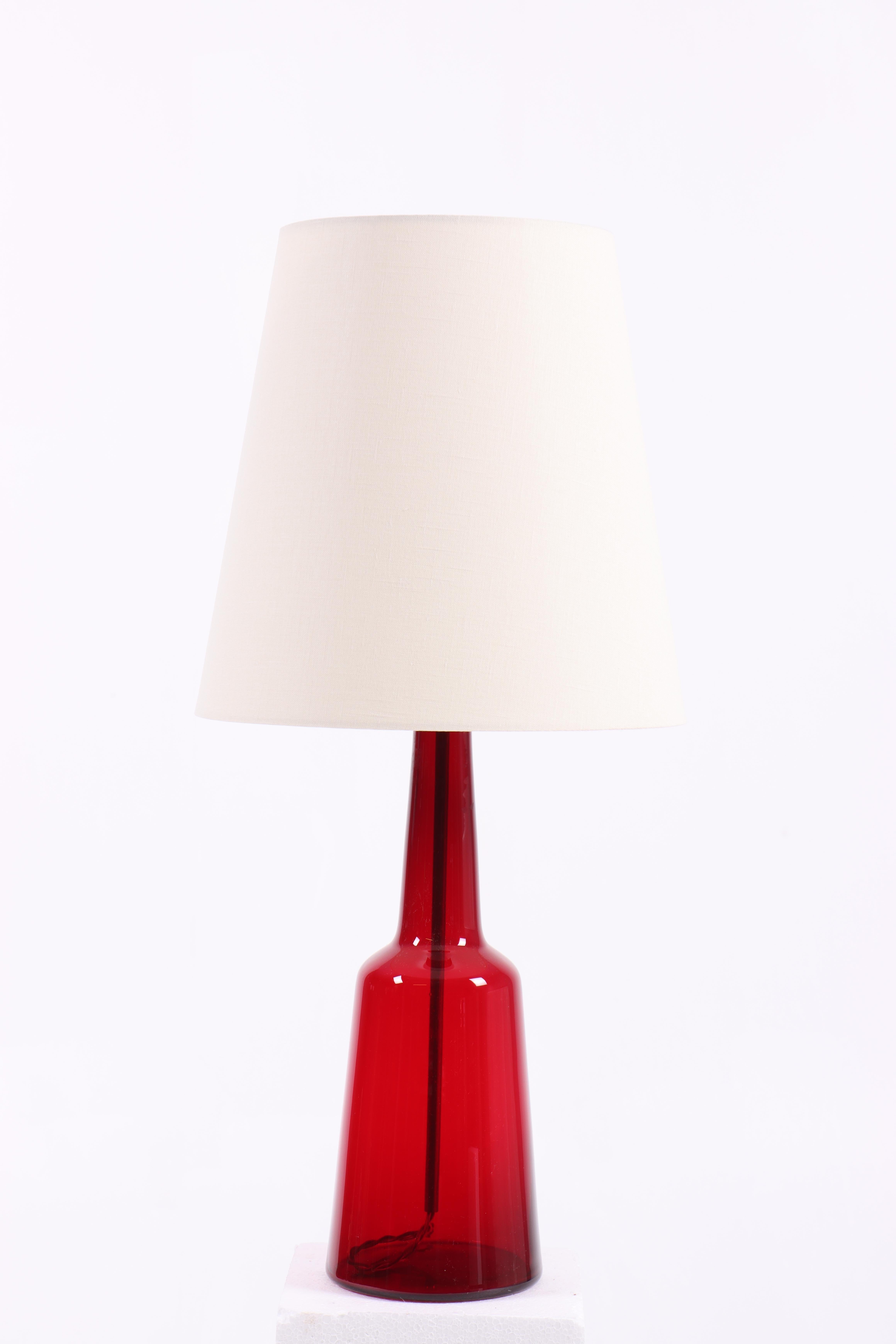 Tischleuchte aus Glas, entworfen und hergestellt von Holmegaard. Hergestellt in Dänemark, 1950er Jahre. Toller Originalzustand. Die Lampe wird mit einem neuen Lampenschirm geliefert.