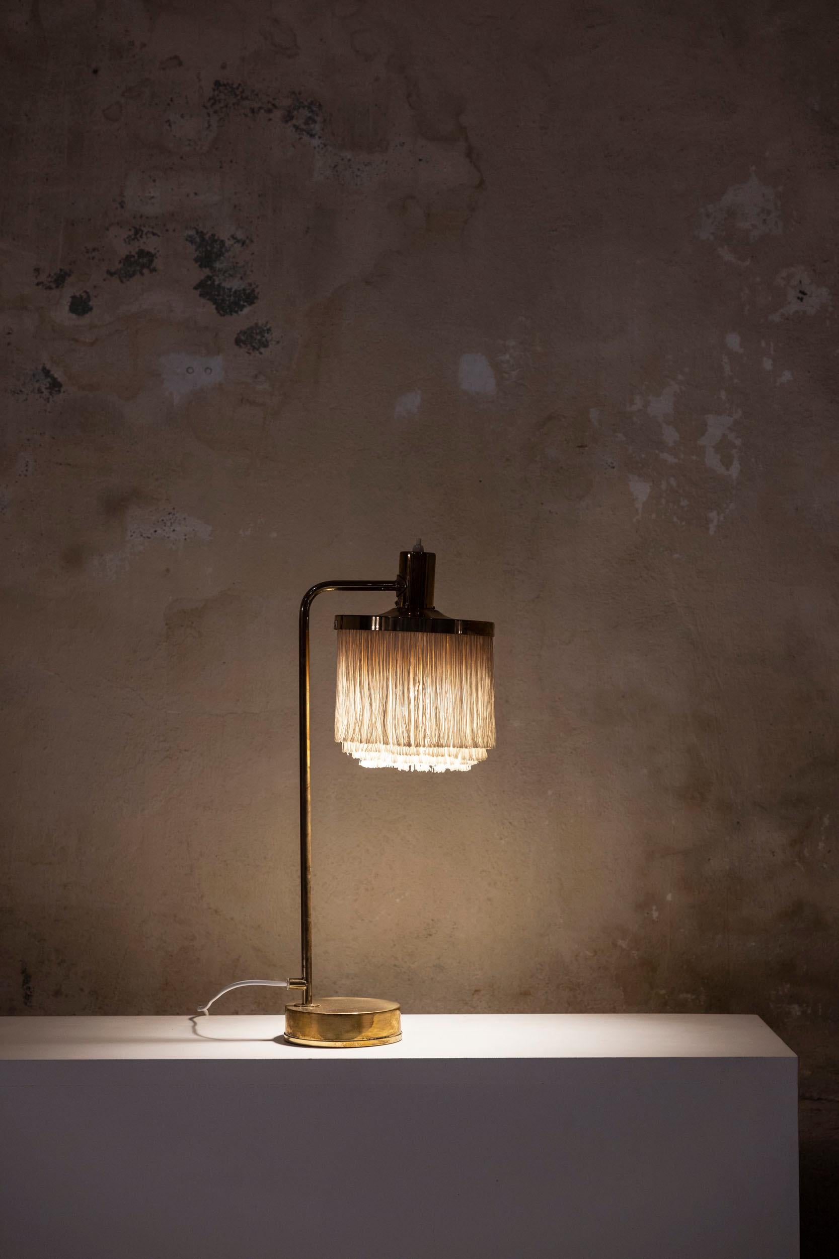 Lampe de table du milieu du siècle par Hans-Agne Agnes, modèle Fringe B-140. Whiting, avec sa structure en laiton et ses franges délicates en soie blanc cassé, ce design élégant présente un bras gracieusement incurvé supportant un abat-jour
