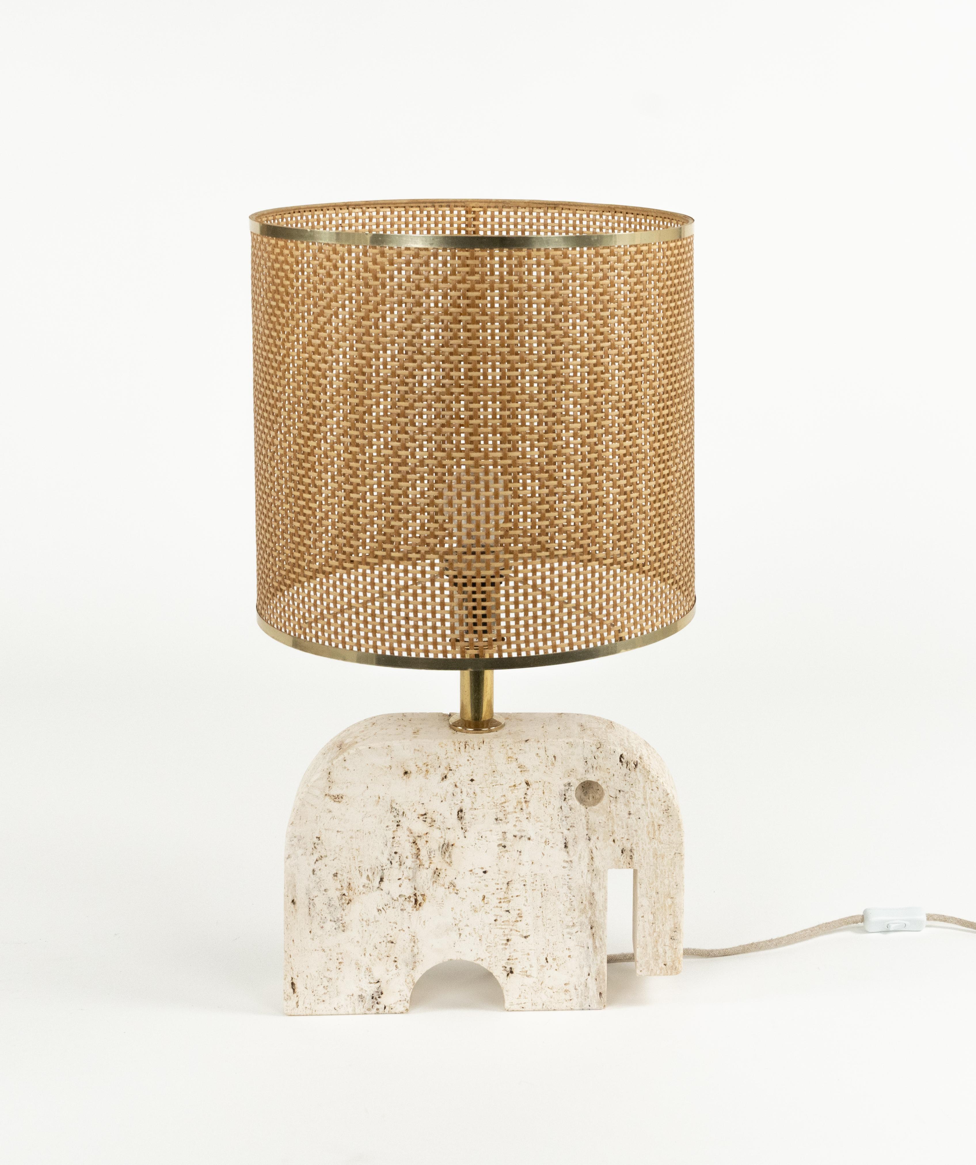 Midcentury amazing sculpture table lamp in travertine shape of a elephant with lampshade in wicker by the Italian Fratelli Mannelli.

Made in Italy in the 1970s.

Dimensions without lampshade: H 36.5 x W 35 x D 7.5 (cm).  
Dimensions with lampshade: