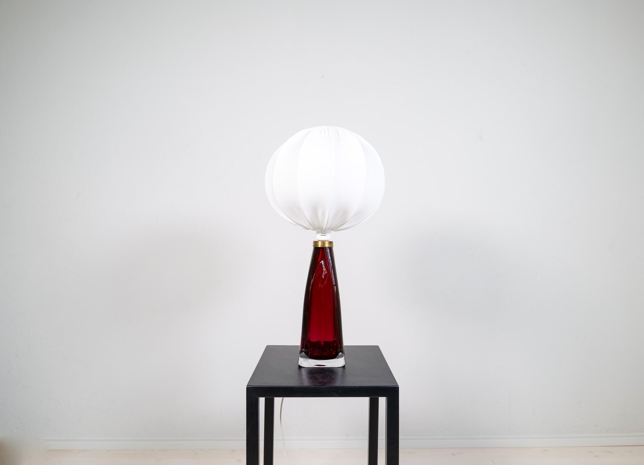Table lamp in crystal, model RD1323 by Carl Fagerlund for Orrefors, Sweden.
The lamps have a stunning red color with brass details. The intensity of the crystal glass and its colored glass inside makes this a great piece. This one with an all-new