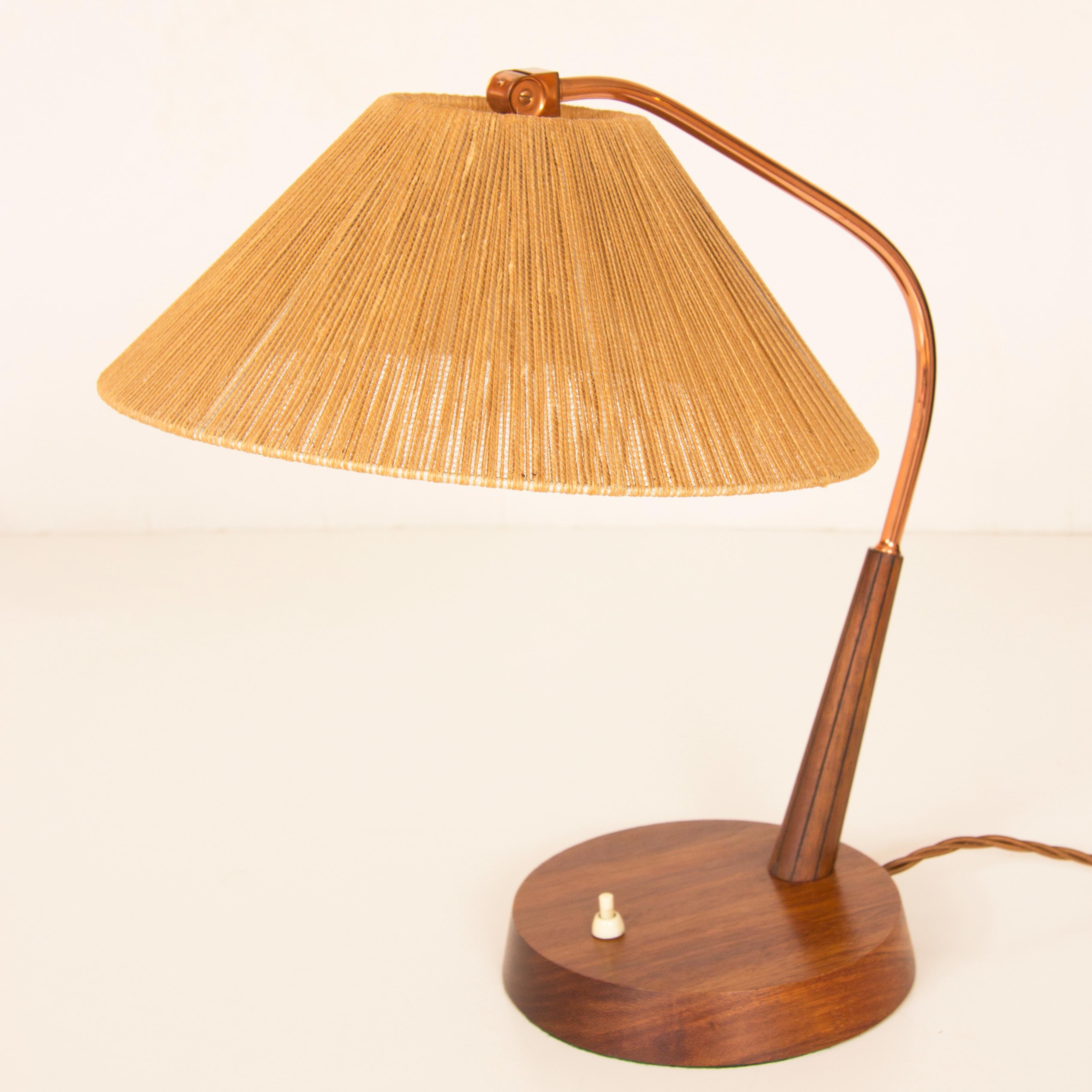 Pair of midcentury table lamps with original jute shades.
A fine pair of table lamps on a turned walnut base, the polished copper arm supported by a reeded and tapered column, the shade can be angled by the ball joint at the top.
Measures: H 43