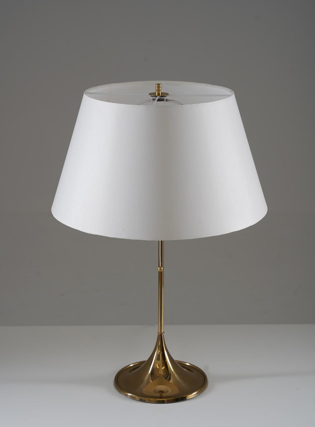 Midcentury table lamps in brass model B-024 by Alf Svensson and Yngvar Sandström for Bergboms, Sweden
The lamps are made of solid brass with a trumpet-shaped foot. 
Condition: Very good condition with signs of age and use. New shades.