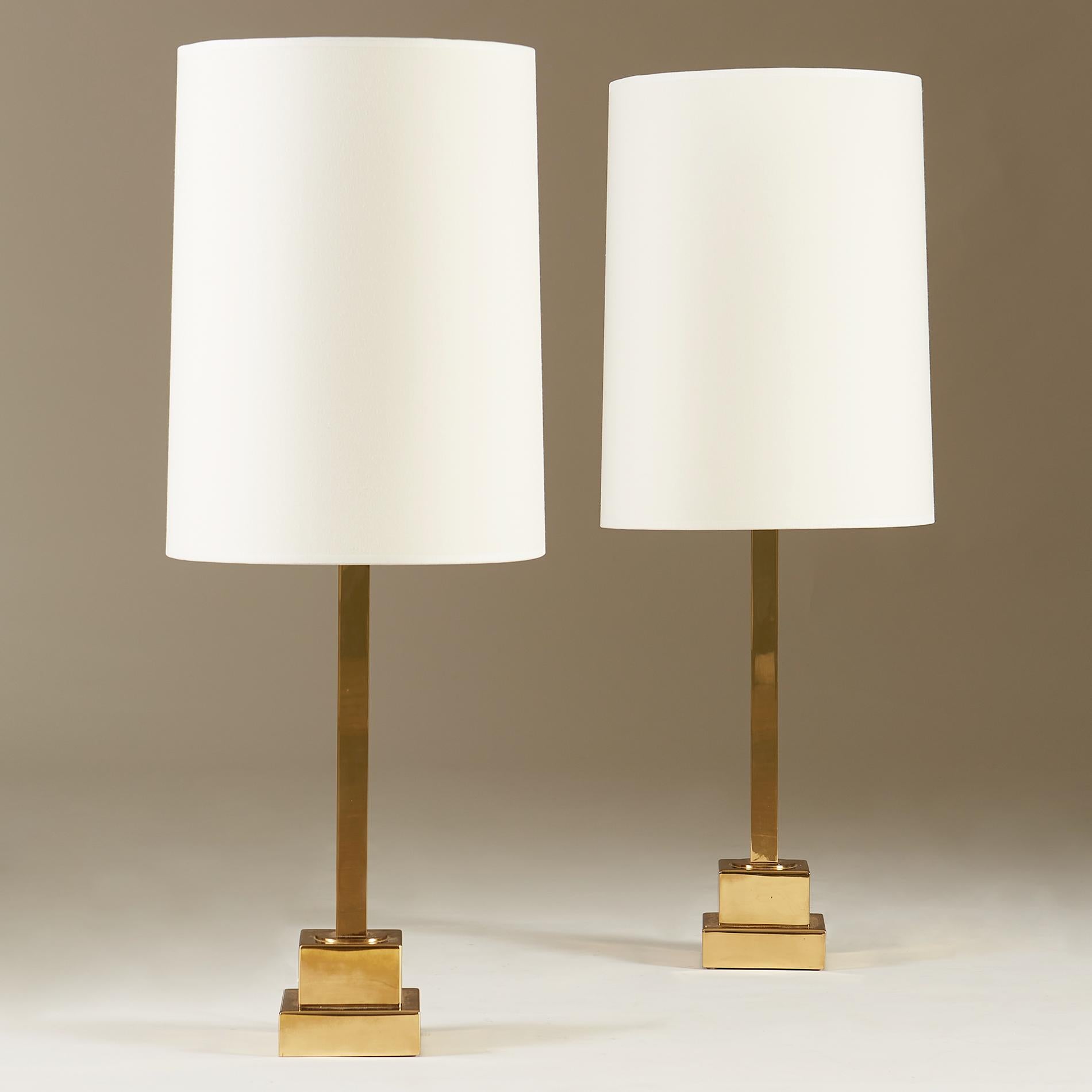 Chic pair of 1960's Bergbom table lamps. Tall brass stem sits on 2-tiered square base. Heavy and imposing. Large cream linen shades compliment the proportions.