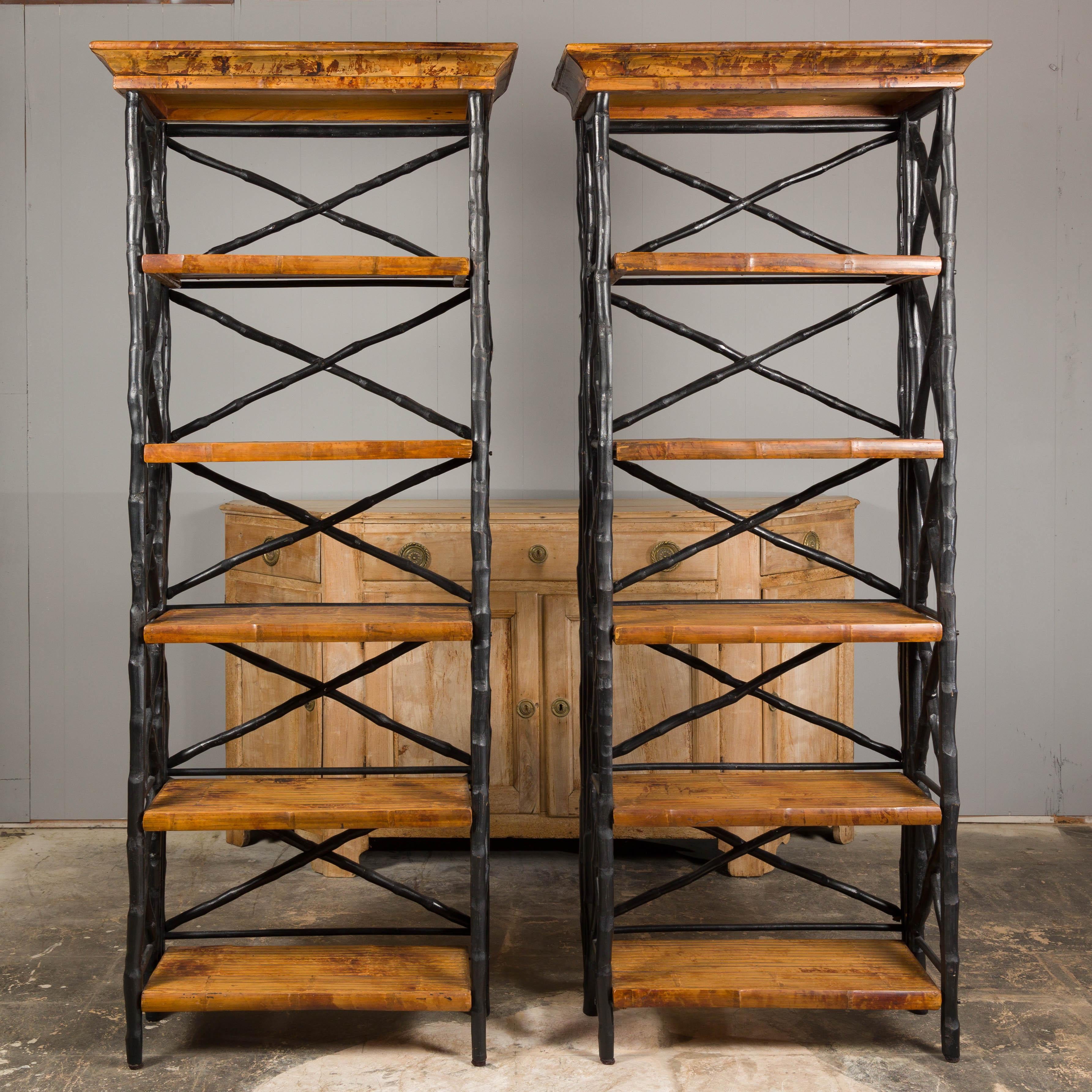 A pair of French tall shelves from the Midcentury period, with black faux-bamboo structure and brown shelves. A stylish manifestation of midcentury French design, this pair of tall shelves, circa mid-20th century, effortlessly merges functional