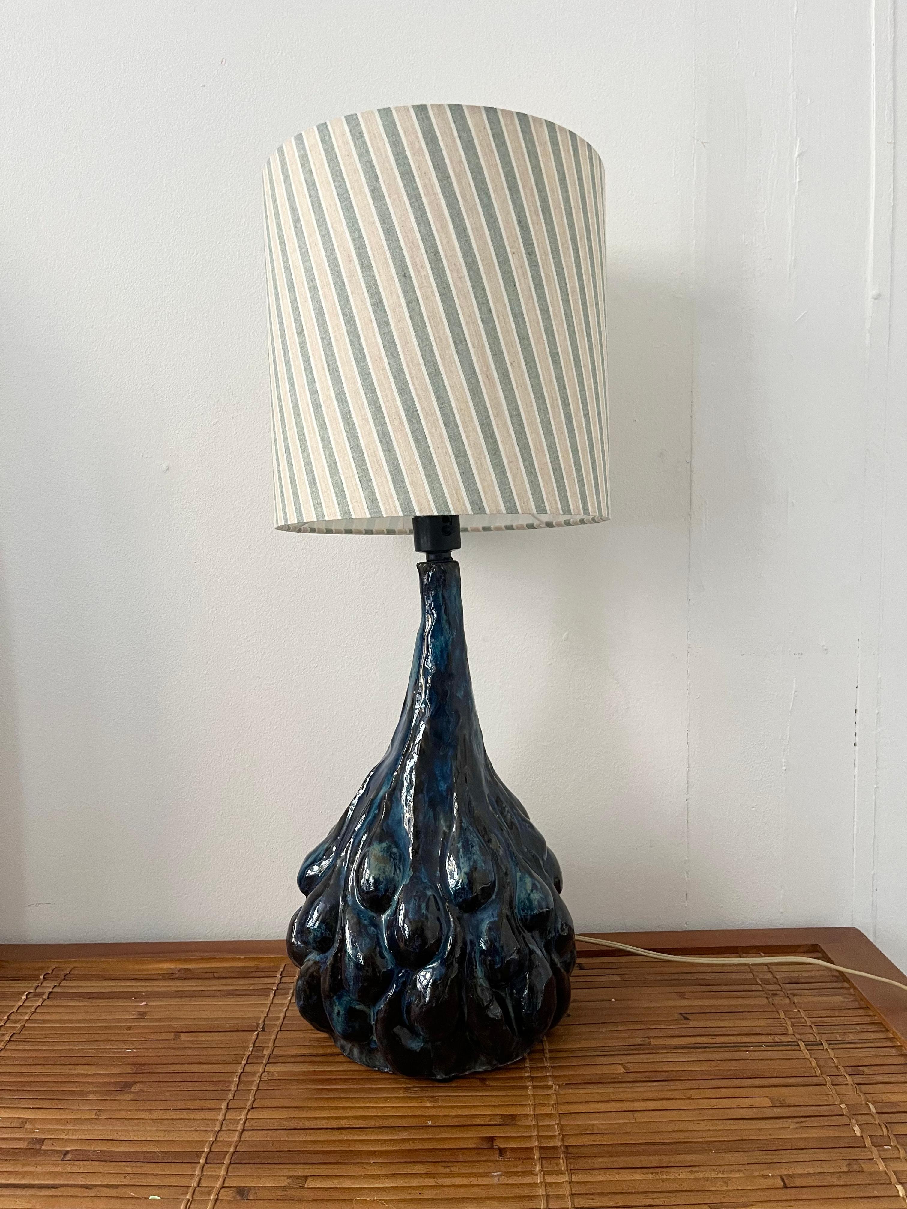Super detailed, super decorative, this tall ceramic table lamp is both rare and impressive in size. It is handmade in shapes that is clearly inspired by Danish master Axel Salto, the glaze is glossy in nuances of blue, brown and blackish brown.