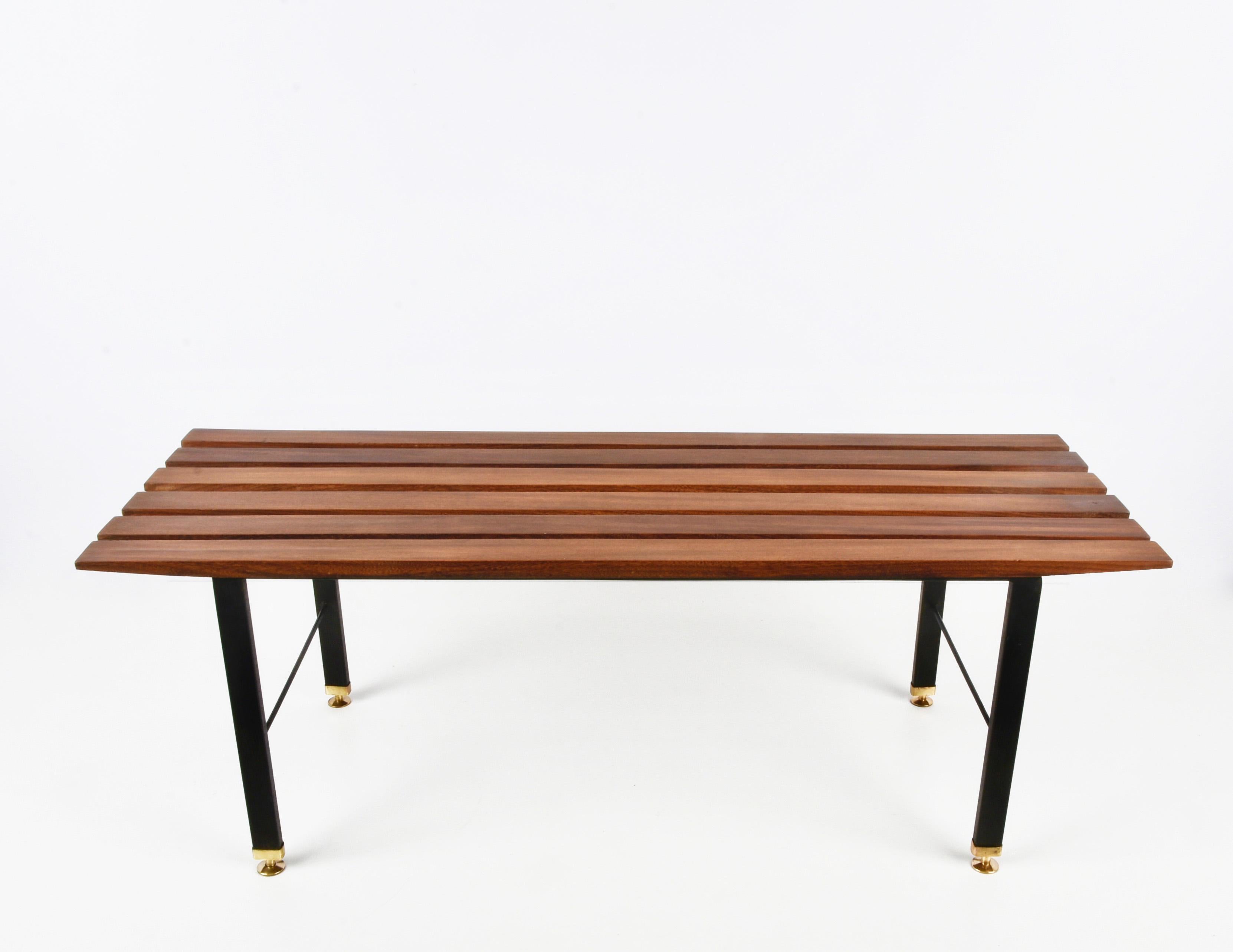 Mid-Century bench in teak, black enamelled metal and brass feet. This wonderful piece was produced in Italy during the 1960s.

This bench is fantastic because of its structure: it has the horizontal lines are in teak while the vertical ones are in