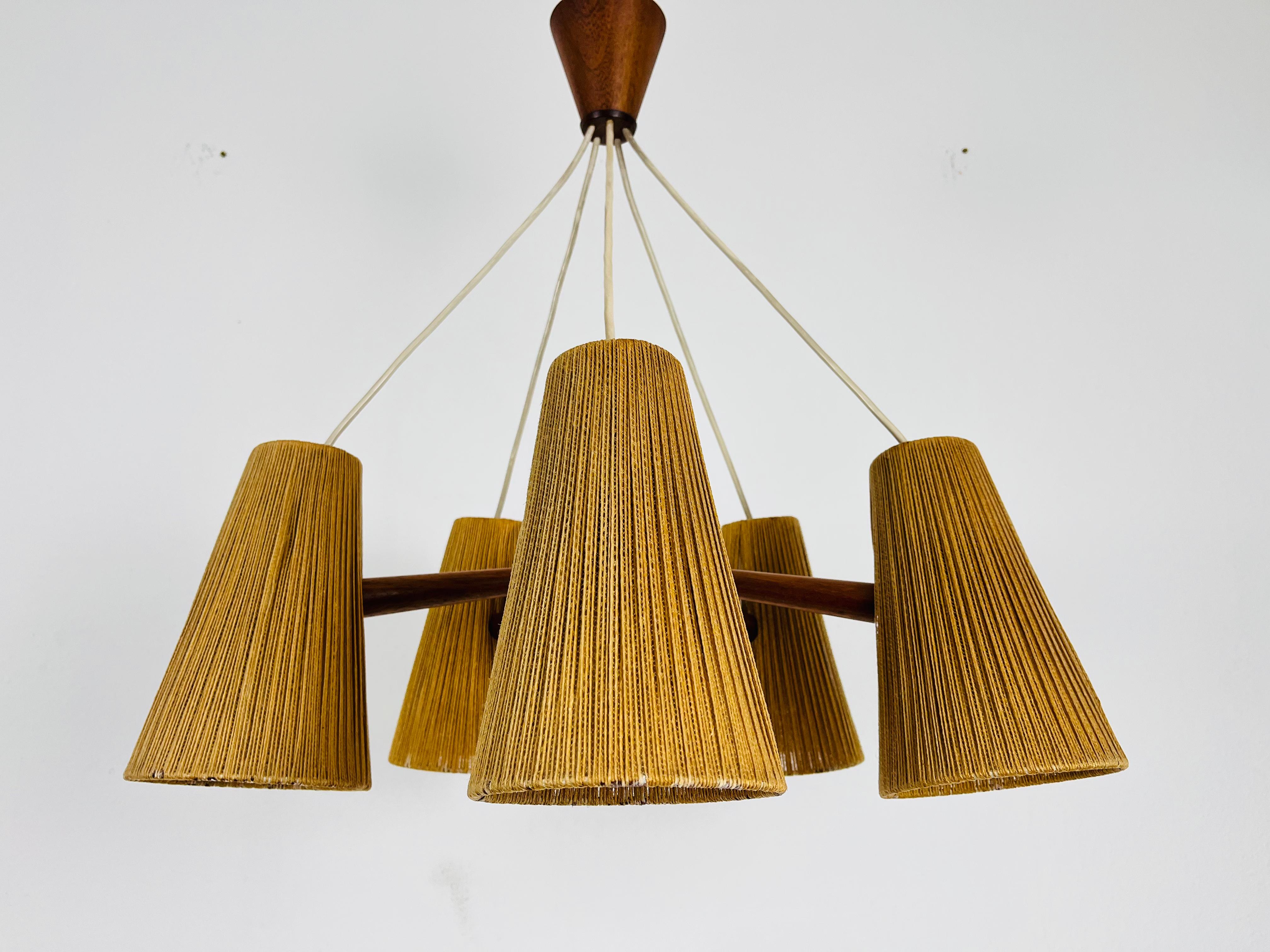 A wonderful suisse teak hanging lamp made by Temde in the 1960s. It is fascinating with its rare cone lamp shades. The body of the lamp is made of teak.

The light requires five E27 light bulbs. Works with both 120V/220V. Very good vintage
