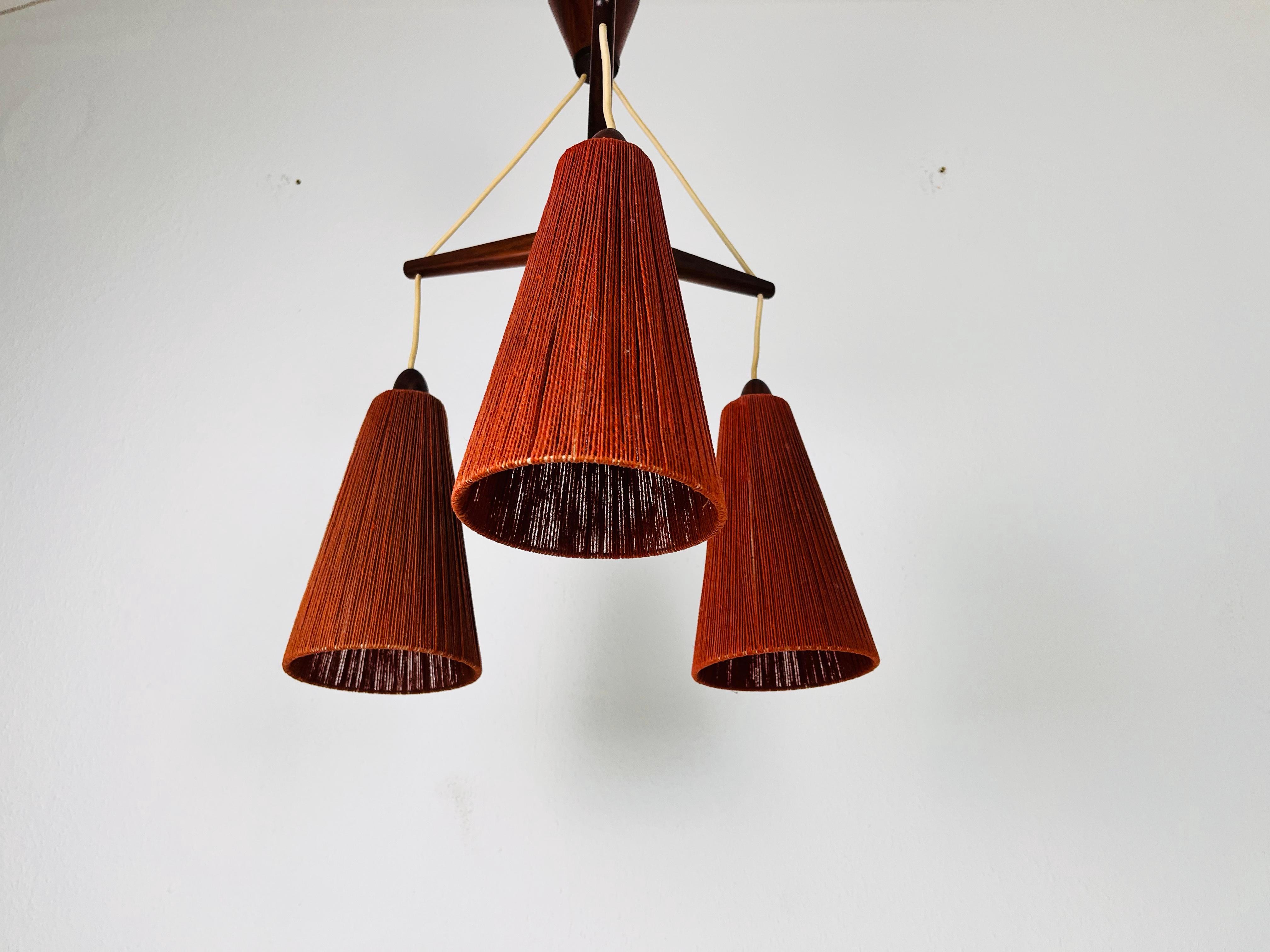 A wonderful suisse teak hanging lamp made by Temde in the 1960s. It is fascinating with its rare cone lamp shades. The body of the lamp is made of teak.

The light requires three E27 light bulbs. Works with both 120V/220V. Very good vintage