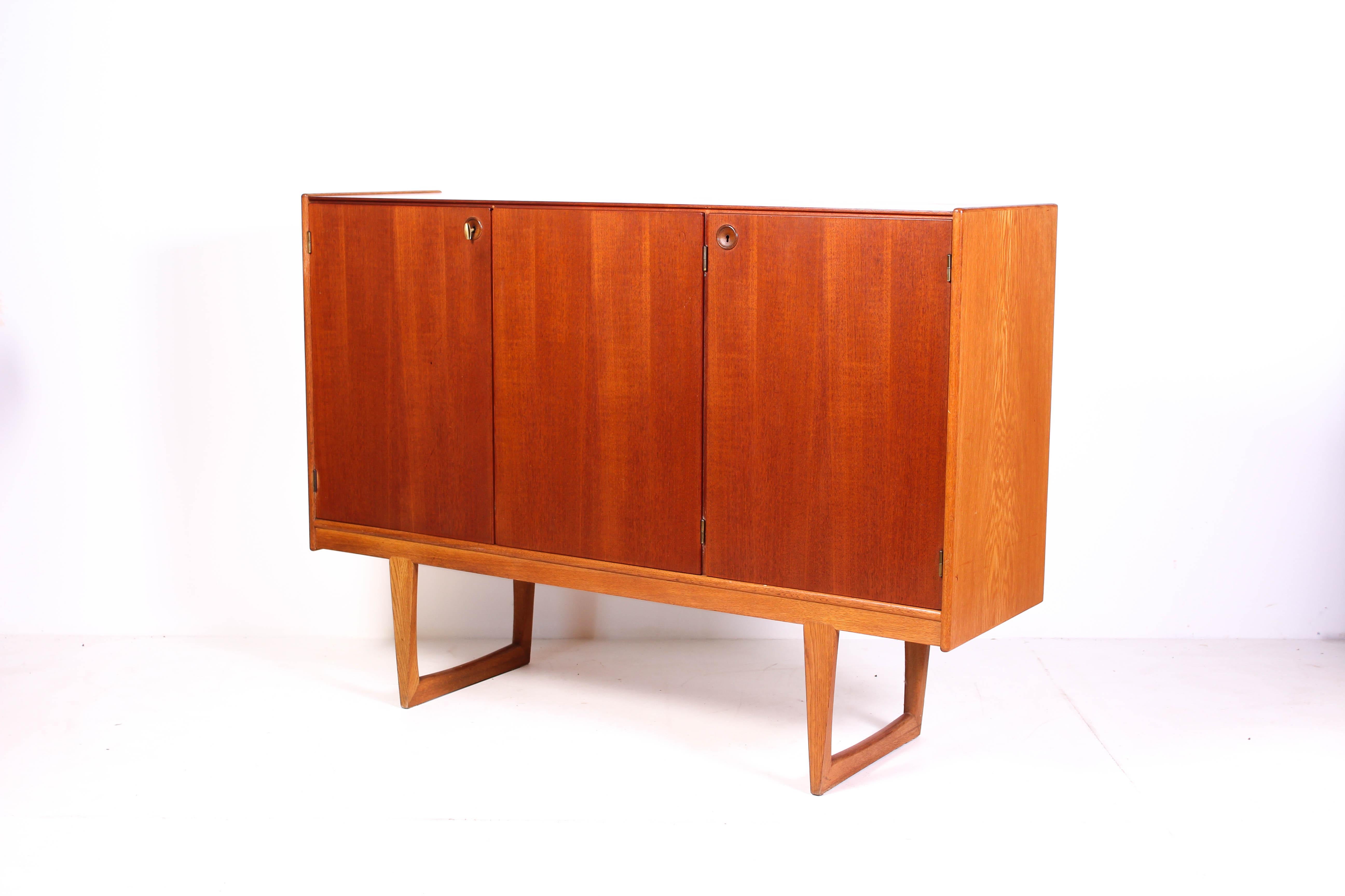 Midcentury sideboard by Swedish designer Yngvar Sandström manufactured by Nordiska Kompaniet. The sideboard has a teak front and legs and sides made out of oak. 

The sideboard is in very good vintage condition with minor signs of usage consistent