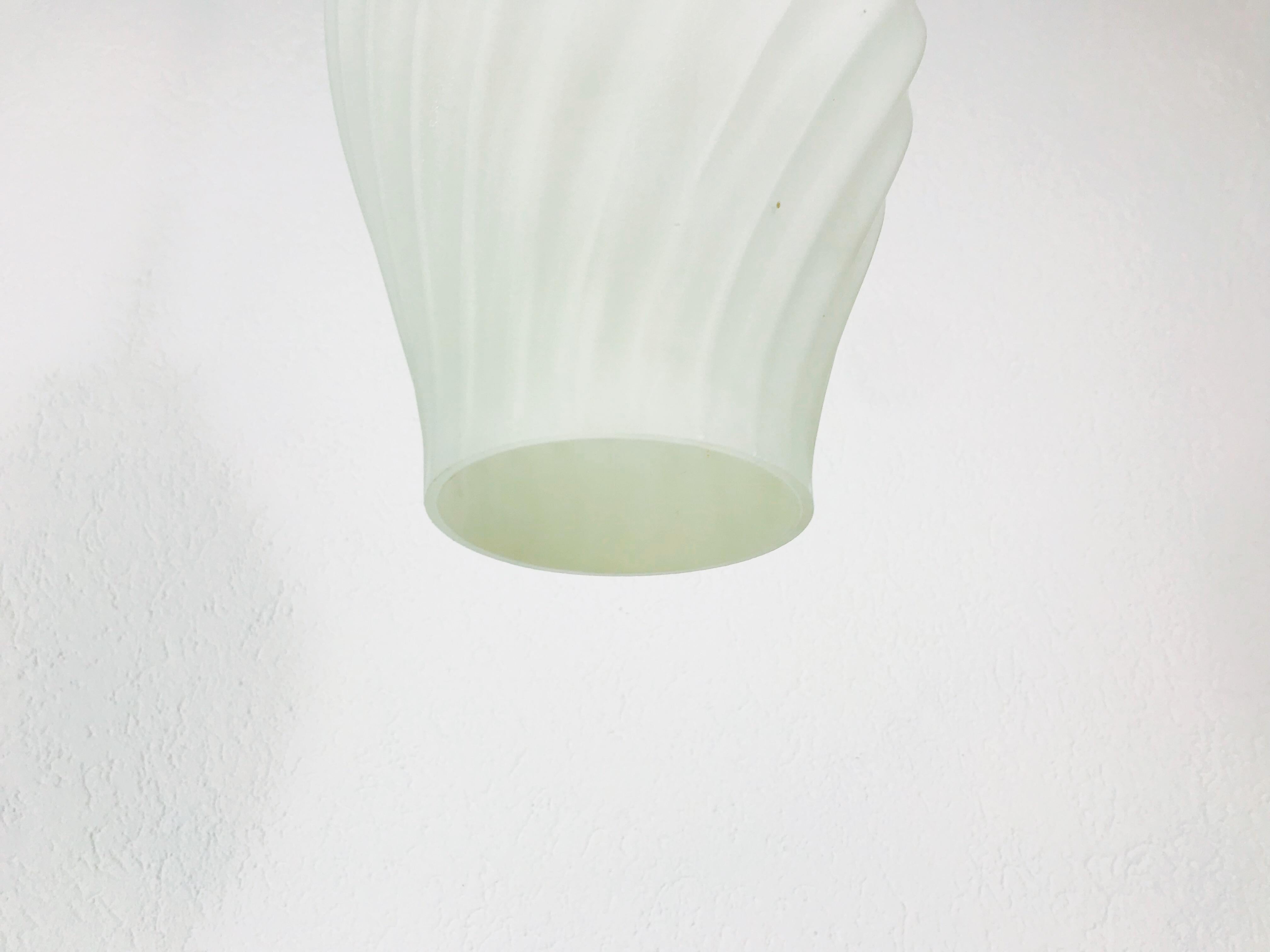 A teak and white opaline glass made in the 1960s. The glass shade is made of thin opaline glass and has an octagonal shape. The top of the lamp is teak. The lamp has a Scandinavian design.

The light requires an E27 light bulb.