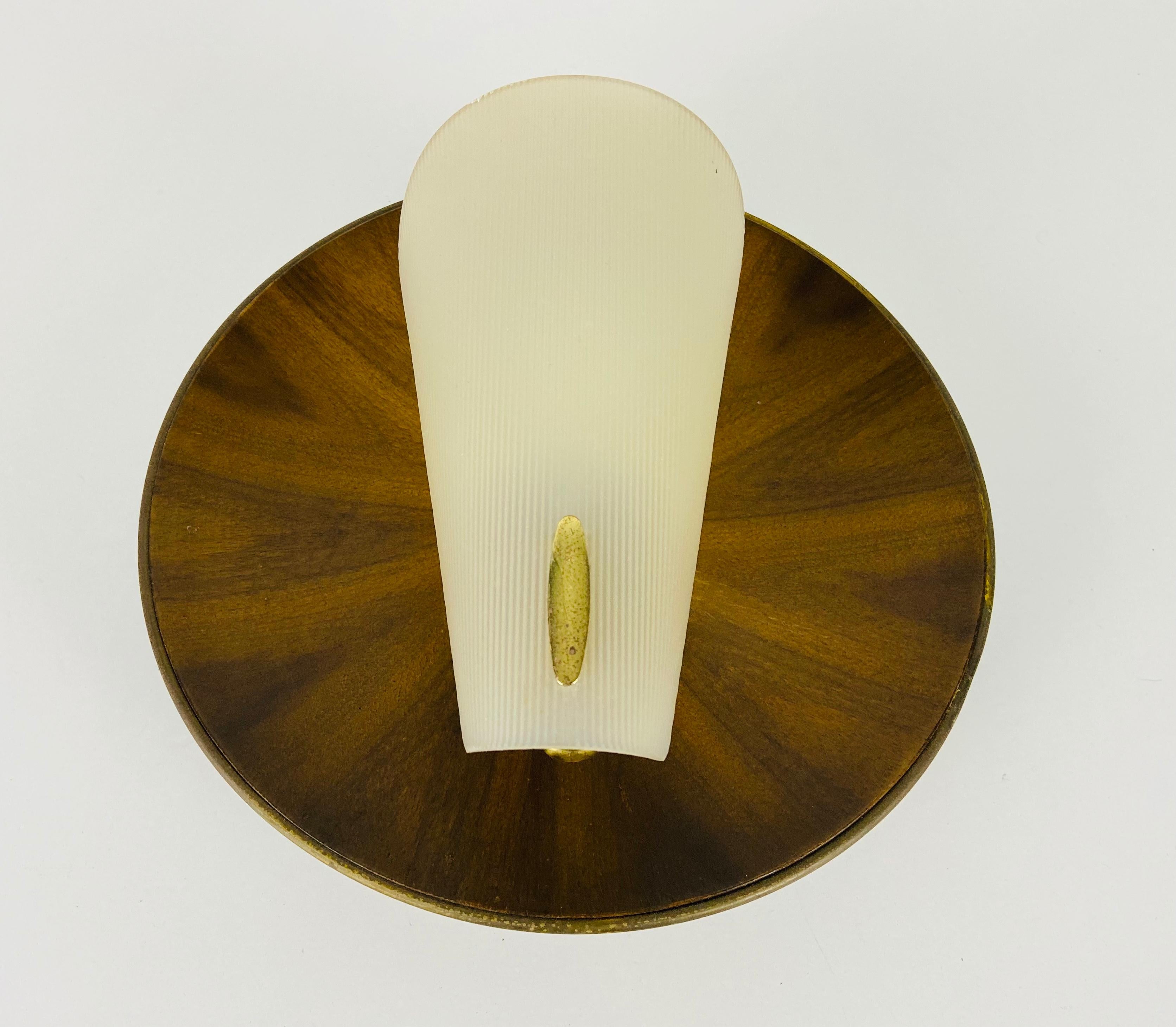 Italian wall lamp made in the 1960s in the style of Stilnovo. It is fascinating with its rare glass shape. The body of the lamp is beautiful teak wood. 

The light requires one E14 light bulbs. Works with both 120/220 V. Good vintage