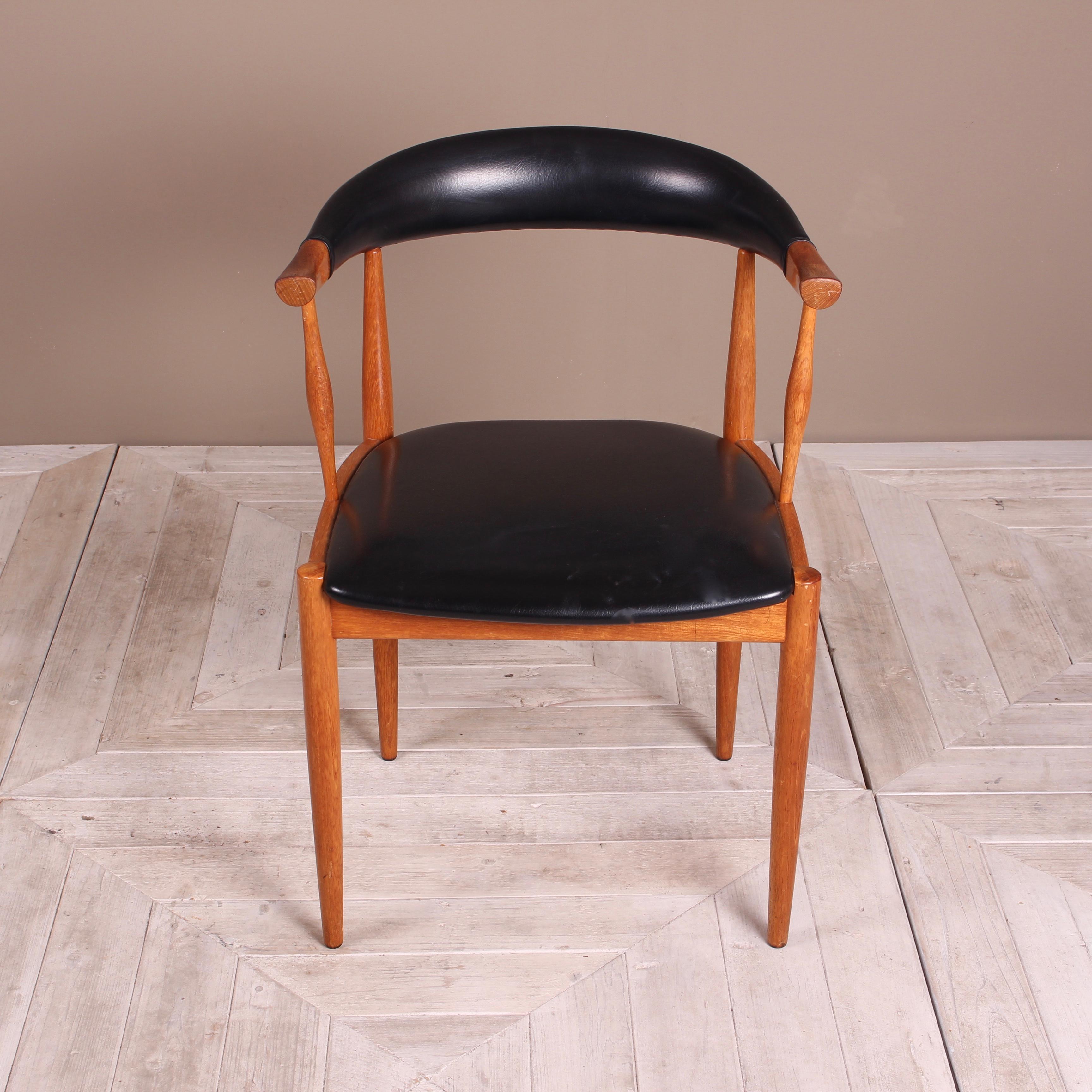 A stylish midcentury teak armchair by Johannes Andersen. Solid teak and faux leather vinyl. A very comfortable and supportive chair. Would also make a good desk chair.