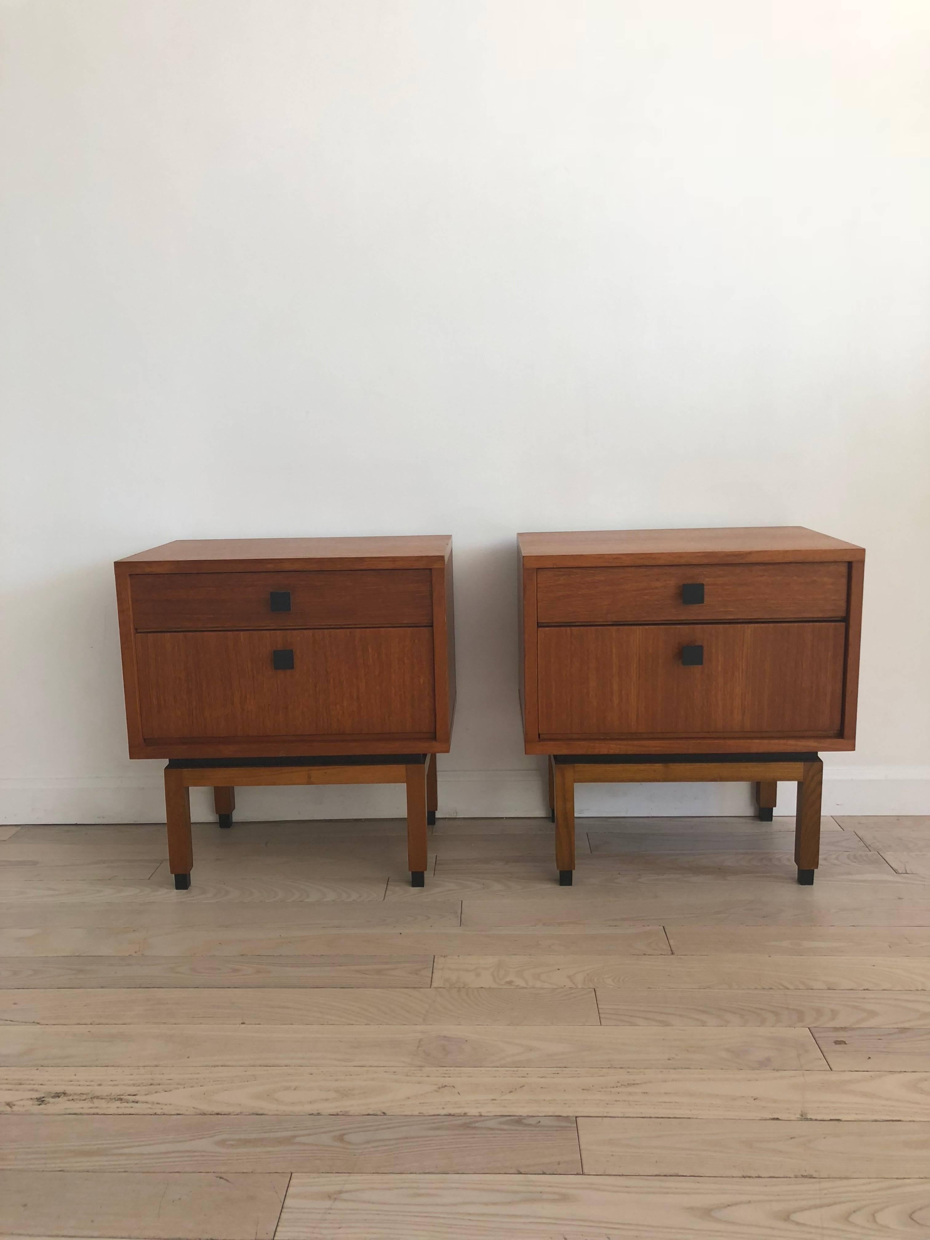 Super cute square shaped pair of midcentury teak nightstands. Cute square legs and square body with square pulls. Excellent vintage condition. Pretty grained teak. Top drawer in each with bottom cubby. Easy and smooth open and close. Rare pair. Made